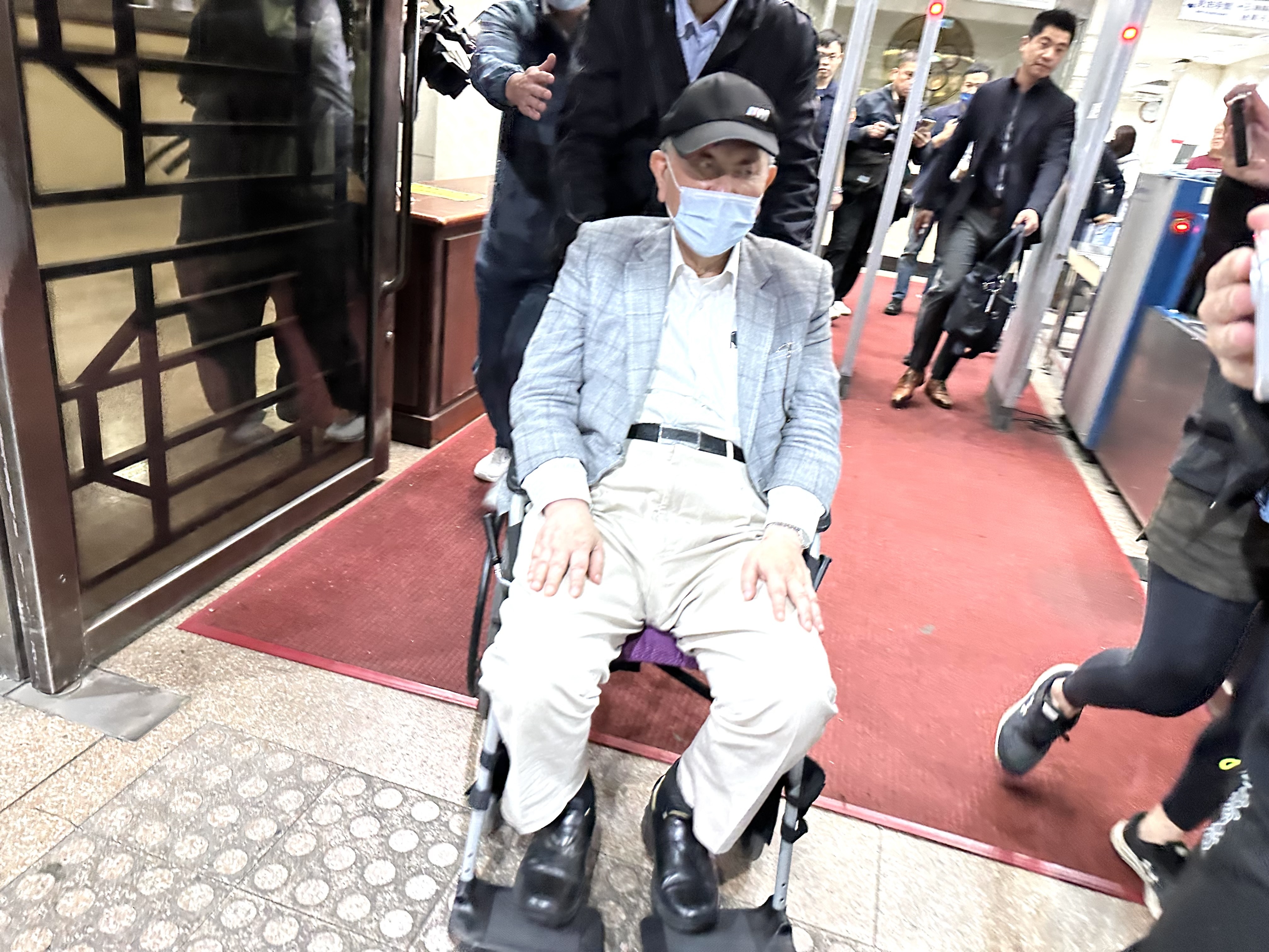 京華城案第二波偵辦，沈慶京700萬交保後坐輪椅飛快離去。