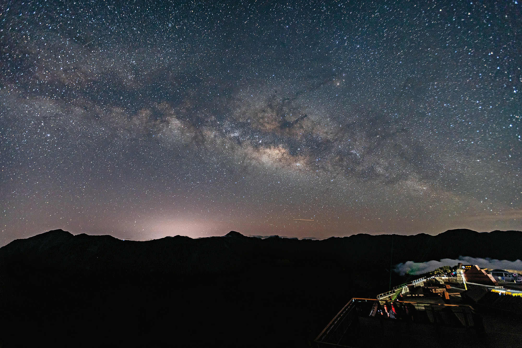 站在昆陽停車場仰望星空，銀河從東南方升起，雲海在腳下翻湧，遠方的山稜線彷彿在與星辰對話，是攝影師推薦給入門者的觀星點之一。