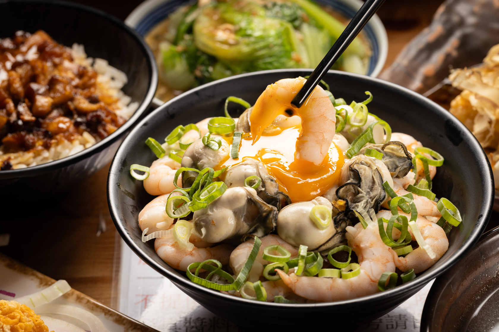 梅菊的「月見龍痛滷肉飯」以老闆引以為傲的滷肉飯為基底，配上汆燙的白蝦仁與鮮蚵。（220／碗）