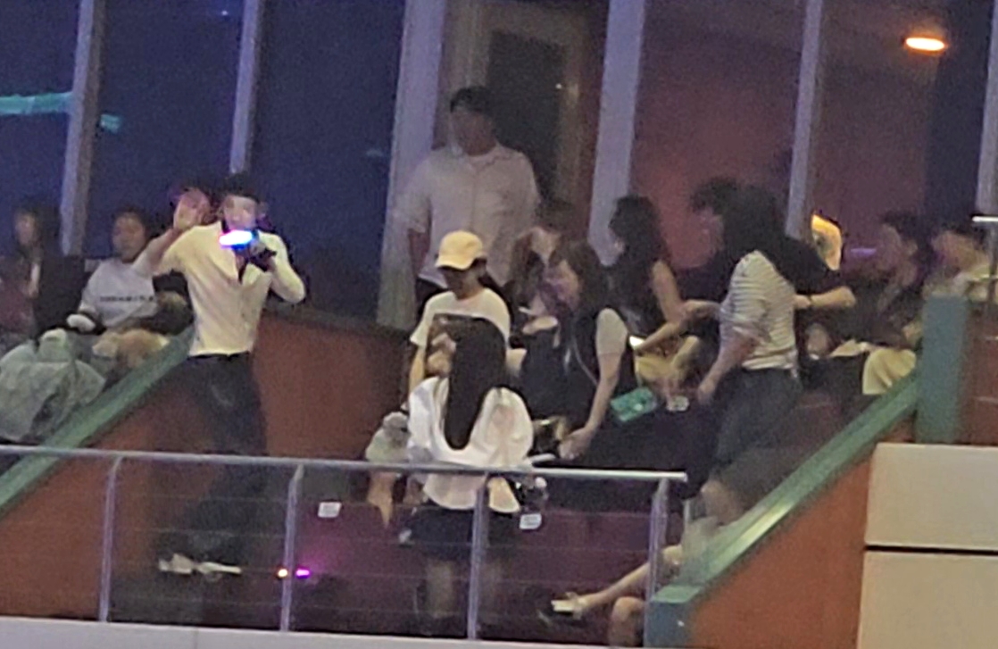 李洙赫向大家打招呼時，白衣女子匆忙地站起來背對大家。（讀者提供）