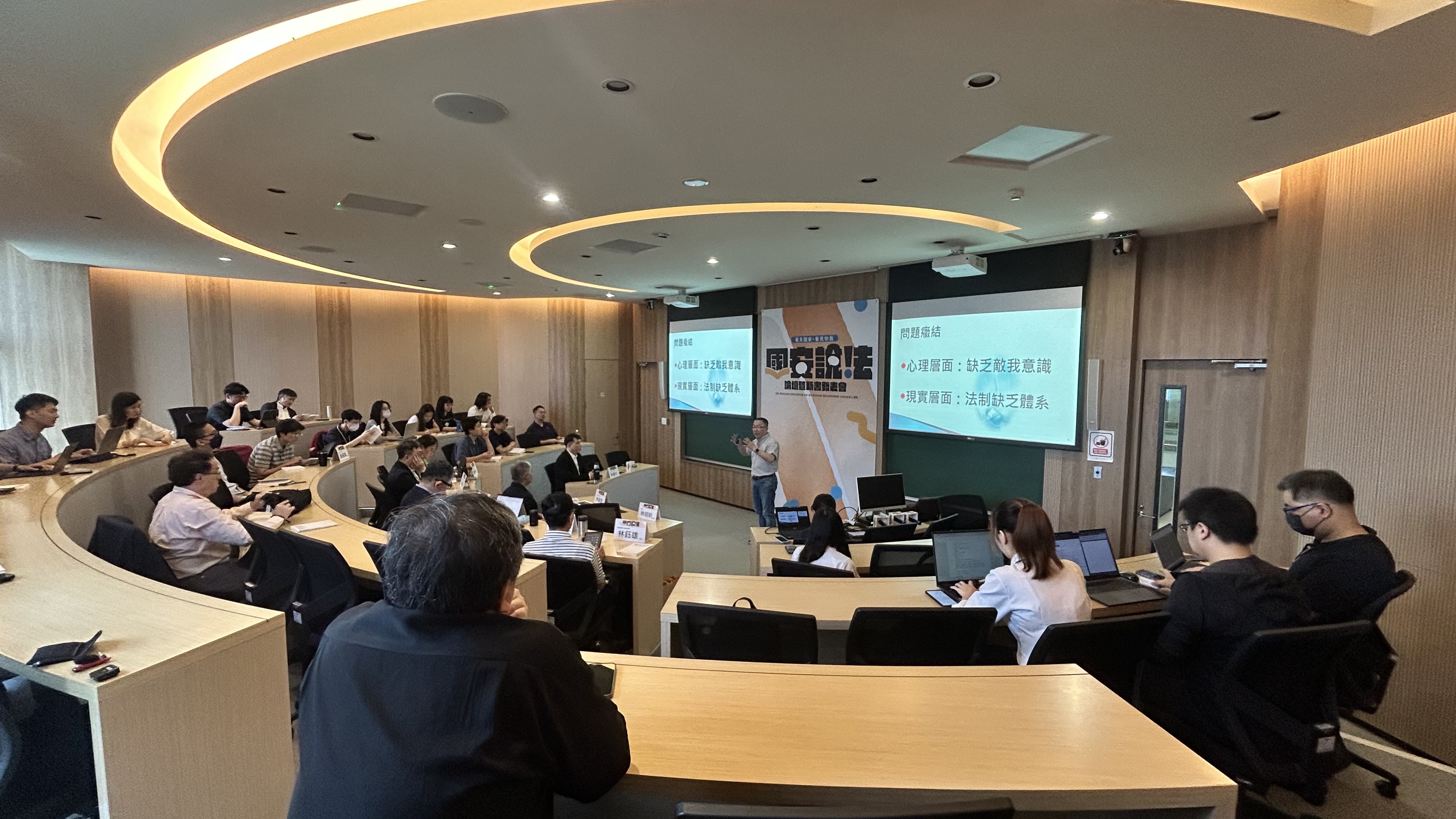 身兼臺大法律學院教授的政務委員林明昕以自己擔任公職1年來的經驗,發表演講,說明現階段儘速建立我國國安法制的必要性與困難度。(民間國家安全與民主韌性法制研究群提供)
