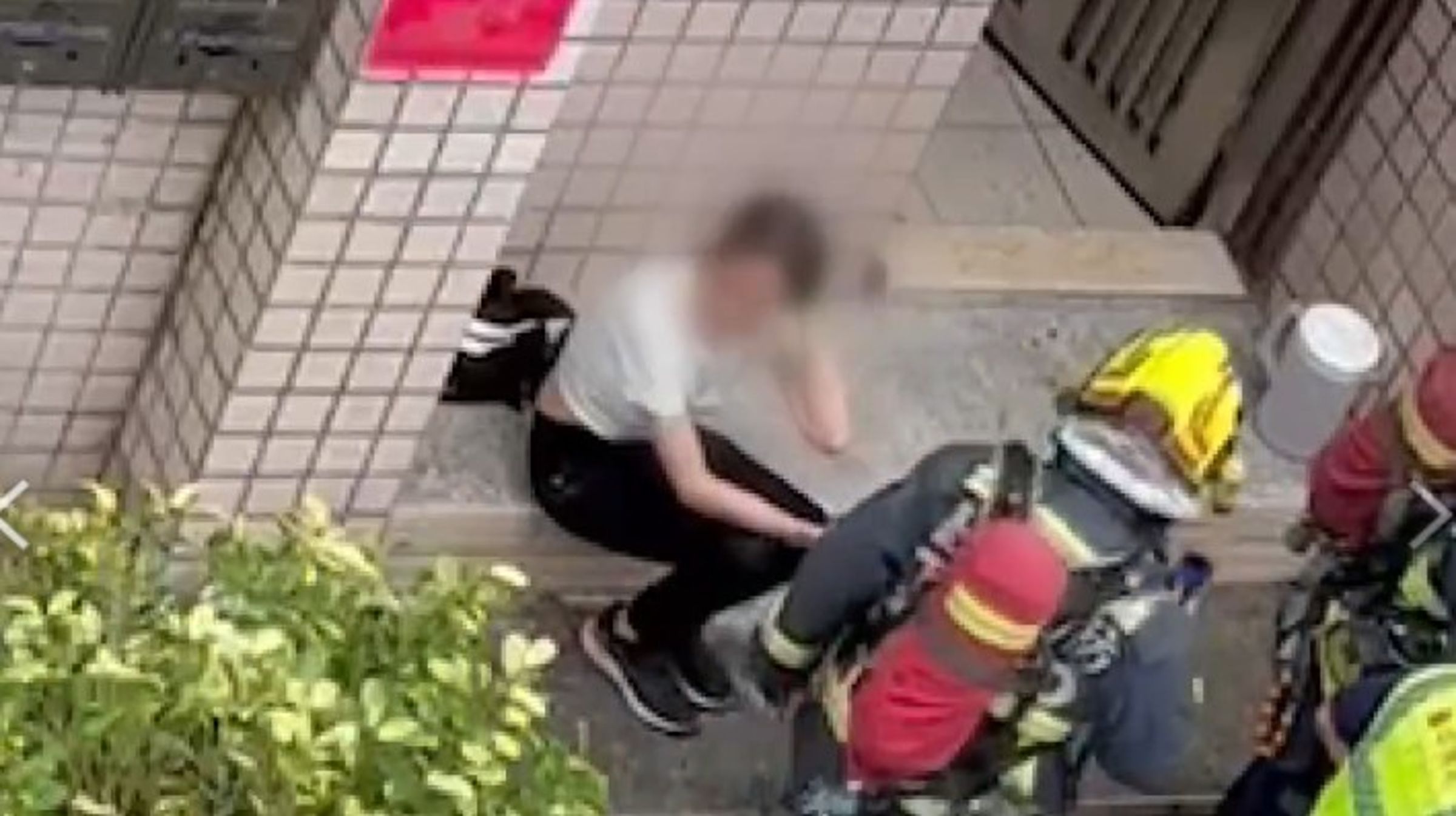 謝女放火後坐在門前哭泣，消防局入屋收拾殘局。（民眾提供）
