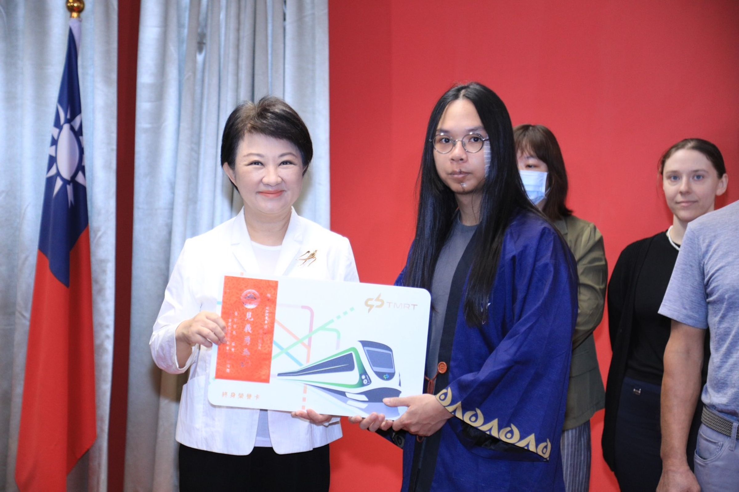 中捷英勇民眾「長髮哥」接收台中市長盧秀燕表揚。(中市府提供)