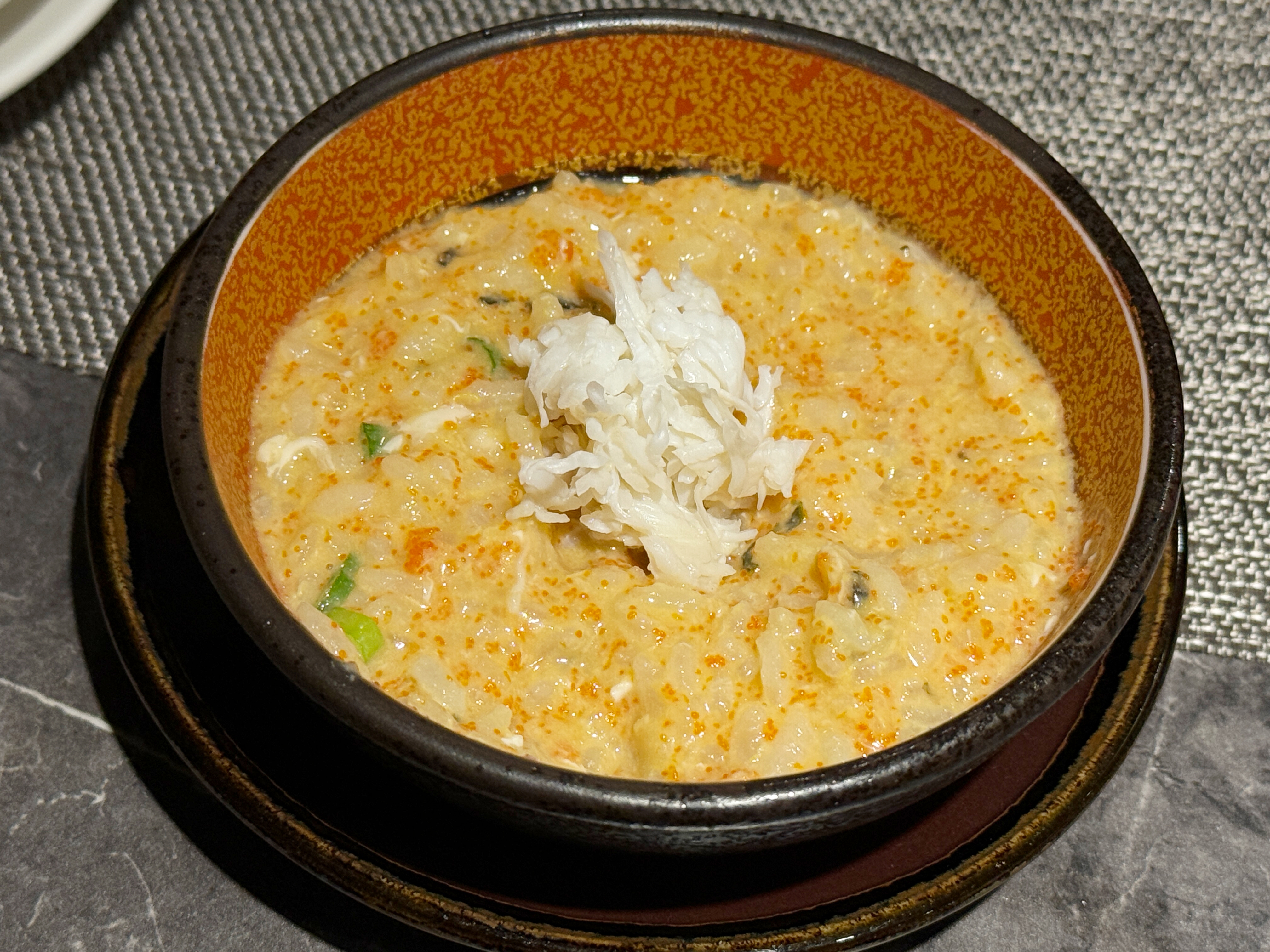 老饕吃法是將「涮煮帝王蟹身」混入蟹膏粥中一起享用。
