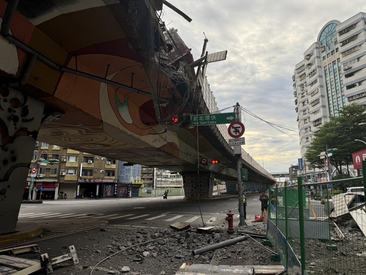 聯結車發生鋼筋掉落意外,也造成橋下方的平面道路因碎石、護欄等,讓整個交通一度大打結。(翻攝自侯友宜臉書)