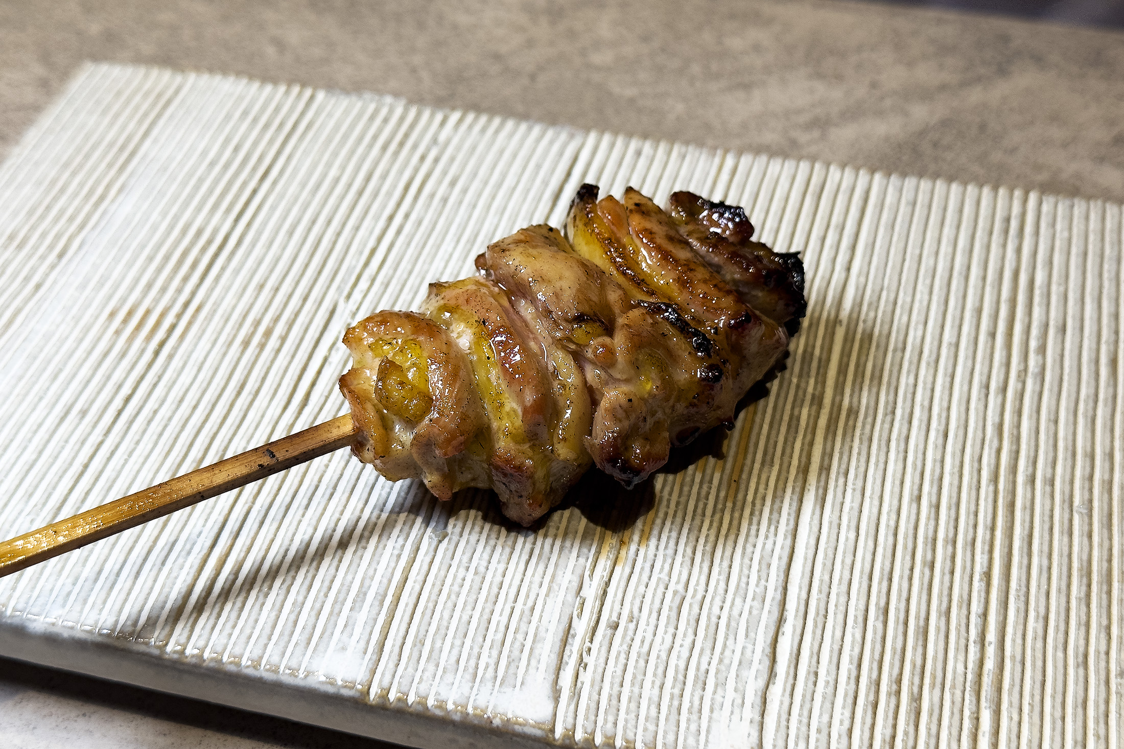 「雞腿肉」選用雞腿腿心部位以直火燒烤，肉質彈性鮮味飽滿。