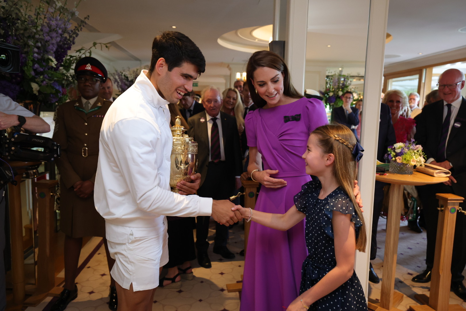 夏綠蒂公主（右）化身「迷妹」，與溫網冠軍阿卡拉茲（左）握手，凱特王妃（中）在一旁介紹。（翻攝Wimbledon X）