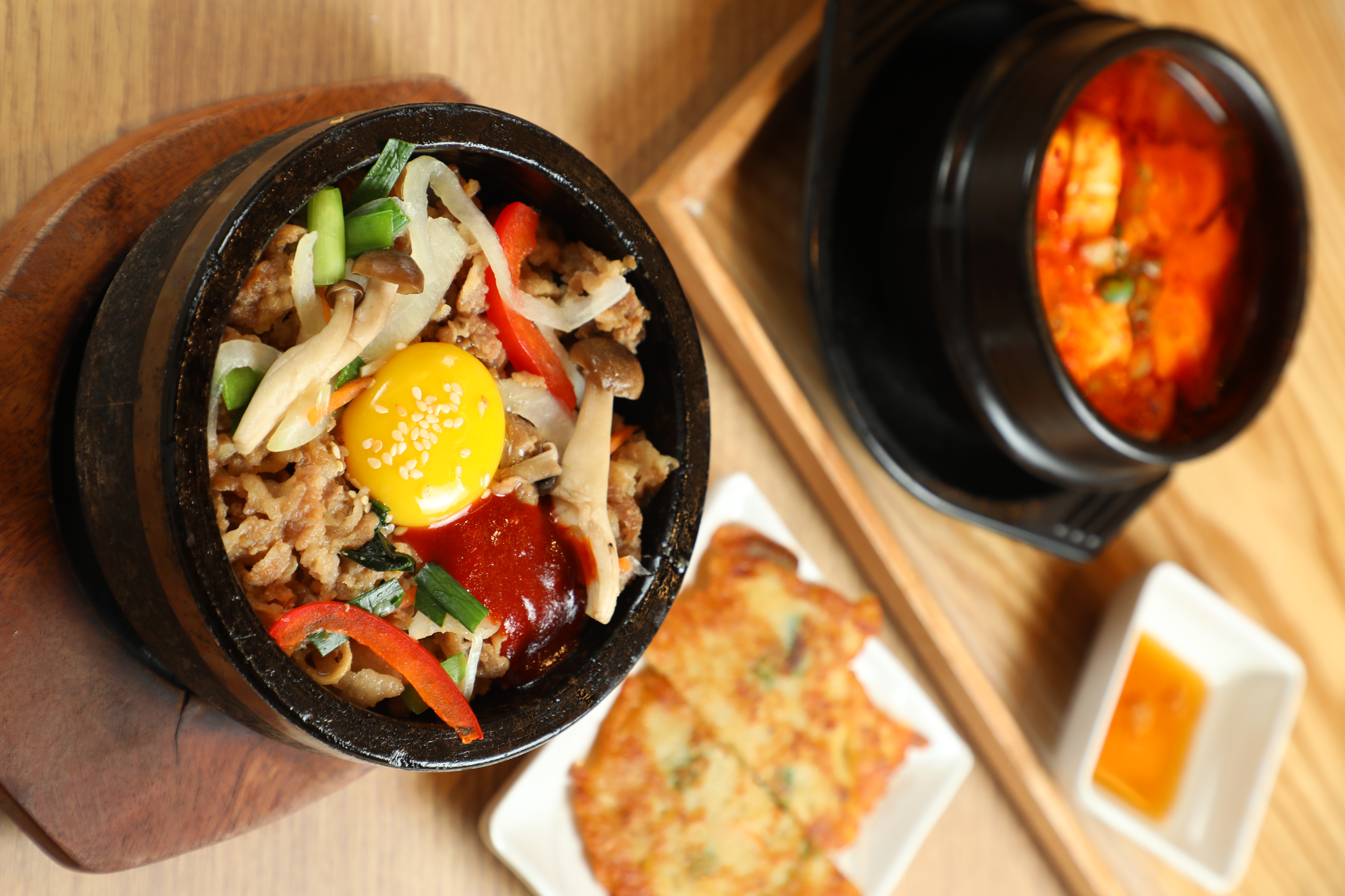 韓美膳半半套餐中的「豬五花石鍋拌飯&海鮮豆腐鍋」都以小鍋承裝，套餐附上2小塊海鮮煎餅。（348元／份）