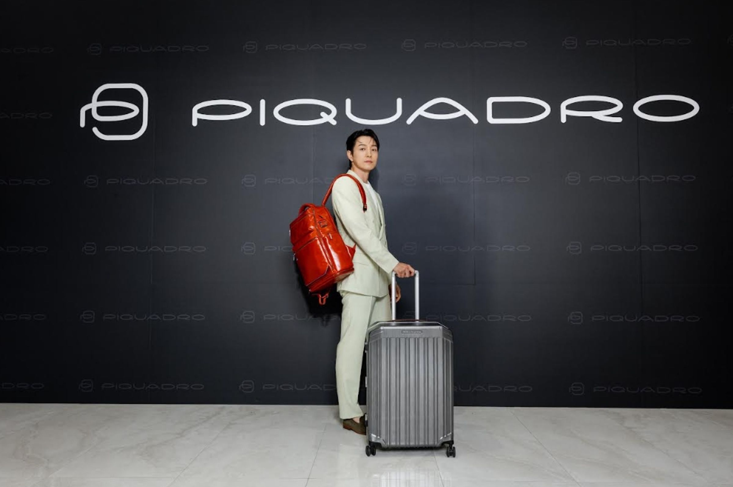 鄭星一身著簡約西裝、搭配PIQUADRO機能皮件出席開幕活動。（PIQUADRO提供）