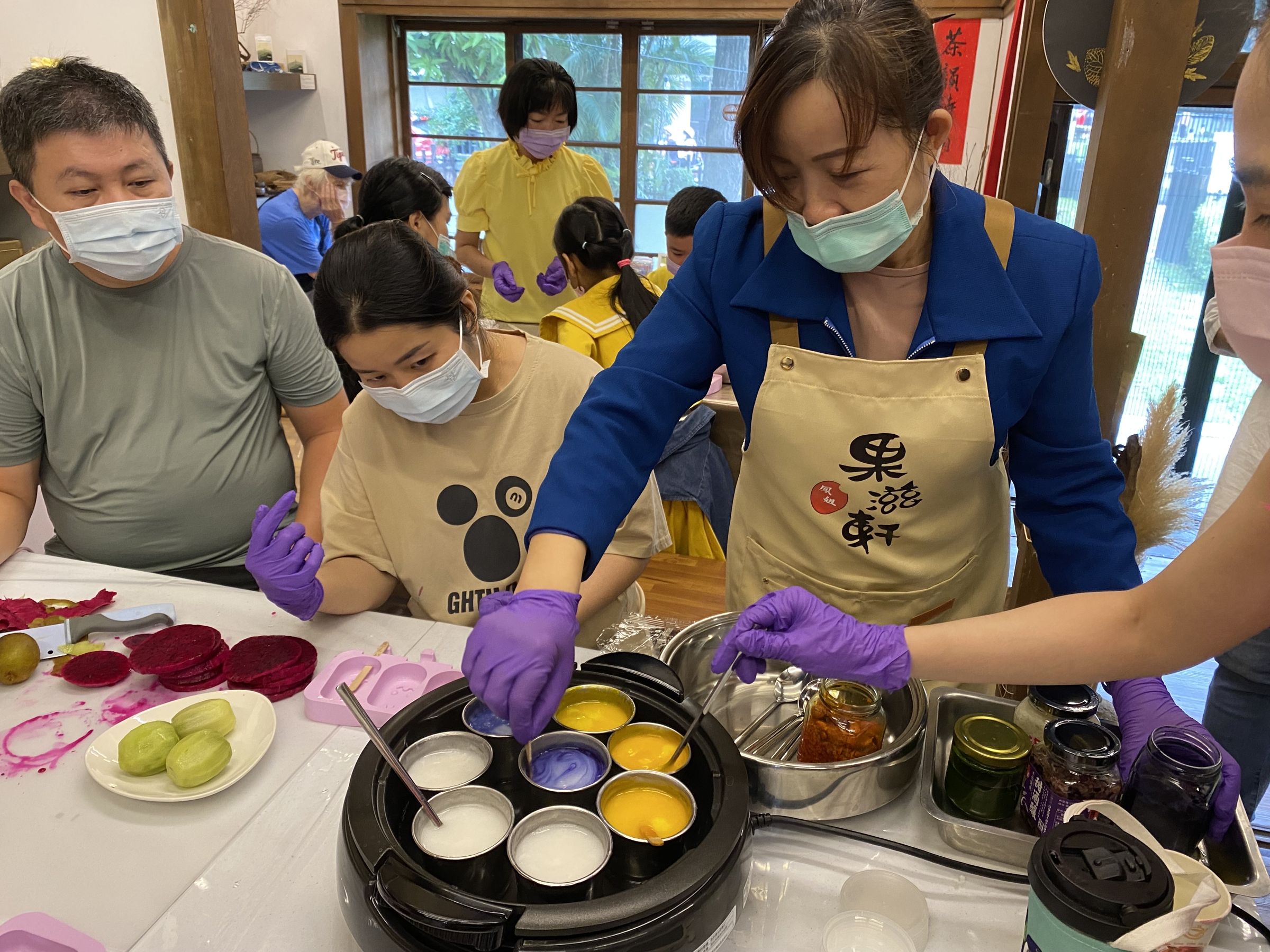 講師劉明鳳(右二)以梔子花、蝶戀花等調製果凍配色。(移民署提供)