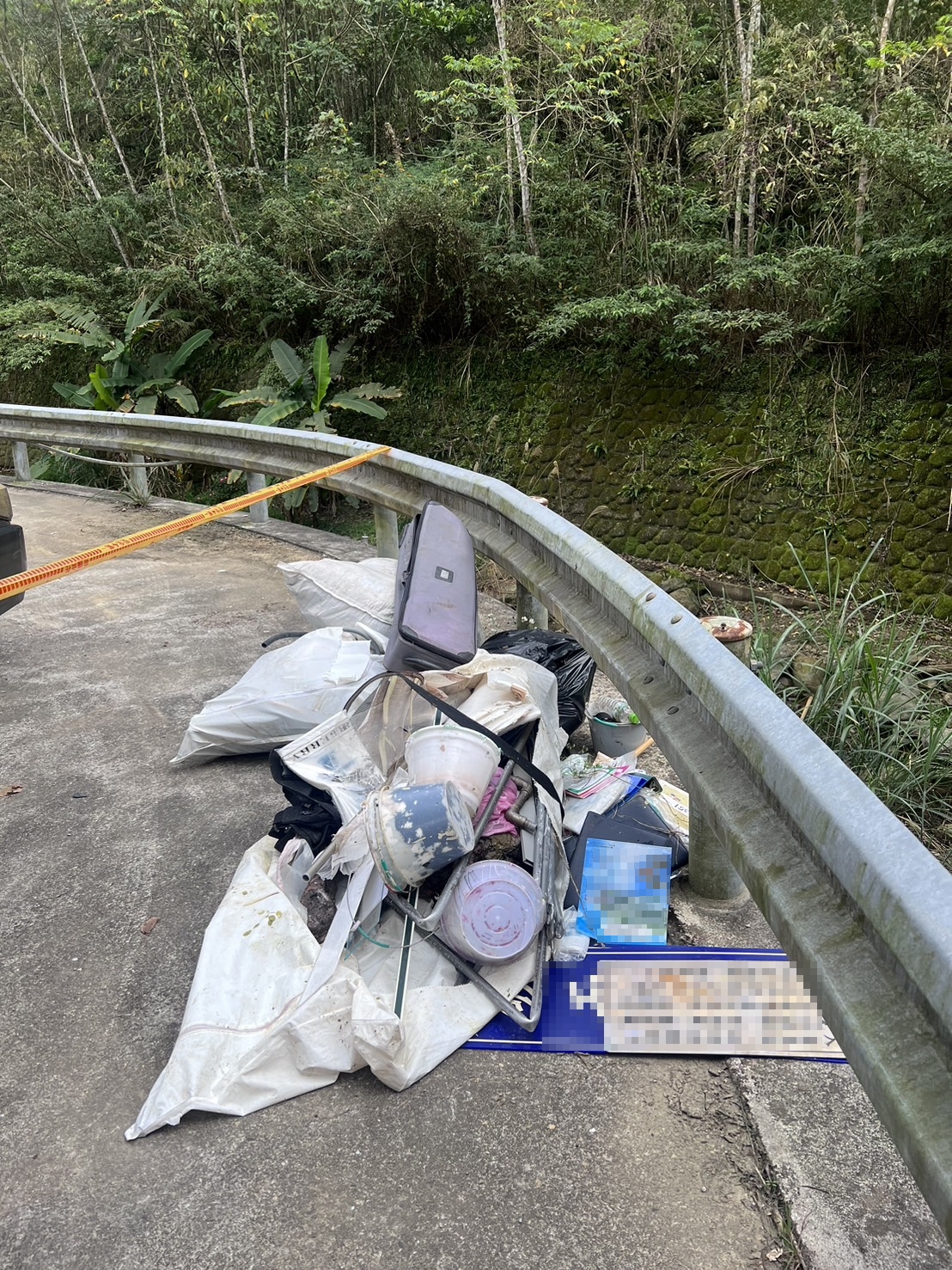 三峽區安坑里附近溪床遭棄置數包廢棄物。(新北市環保局提供)