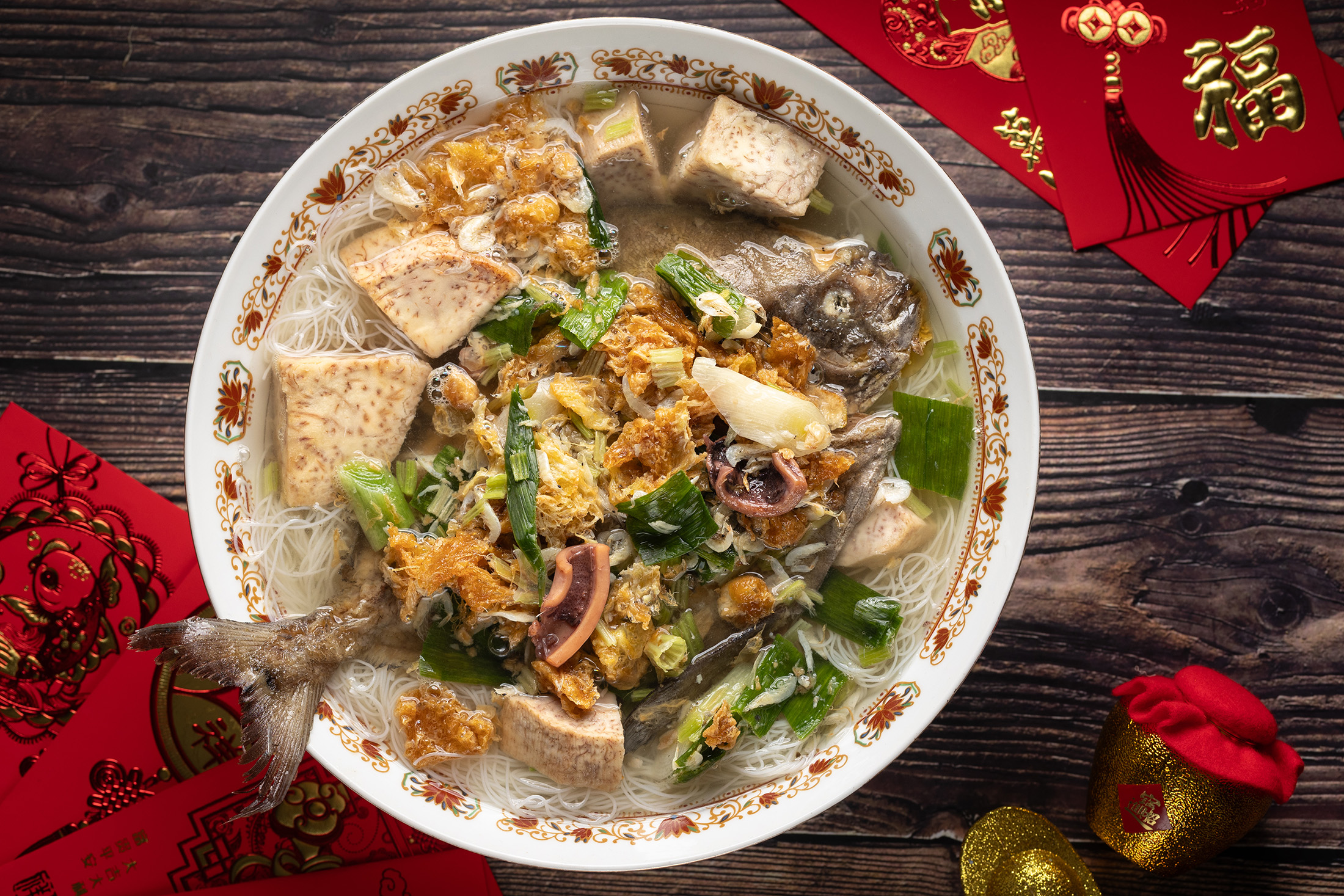 「鯧魚米粉」的魚肉細嫩，湯頭以魷魚等乾貨熬煮，鮮味溫潤，米粉與芋頭吸滿湯汁，是許多長輩指名的圍爐菜。（450元／份）