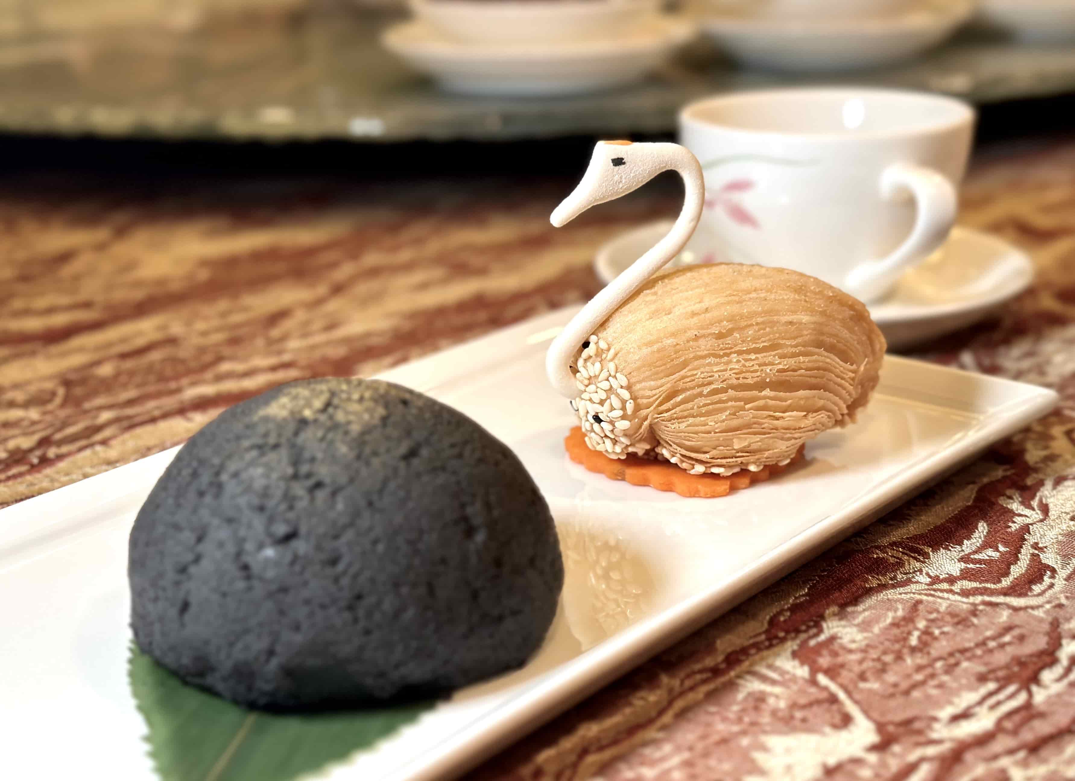 「竹炭焗叉燒包」（前）外層酥軟層次細密，叉燒內餡鹹甜涮嘴。（88港幣／份，約NT$366）