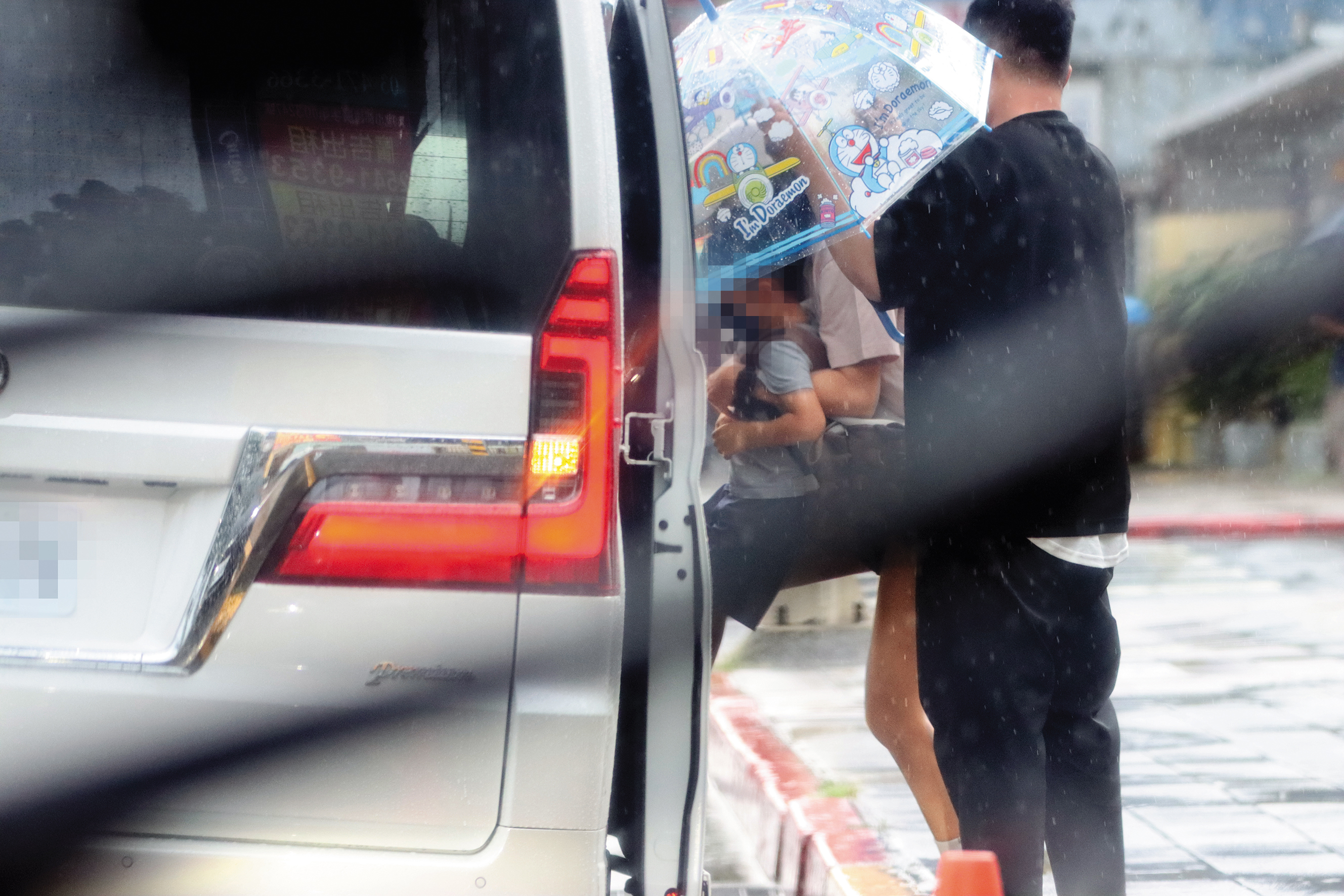 8/15 16：22 安以軒（中）必須手與膝蓋並用，才能把五歲兒子弄上車，此時還下著大雨，感覺更狼狽。