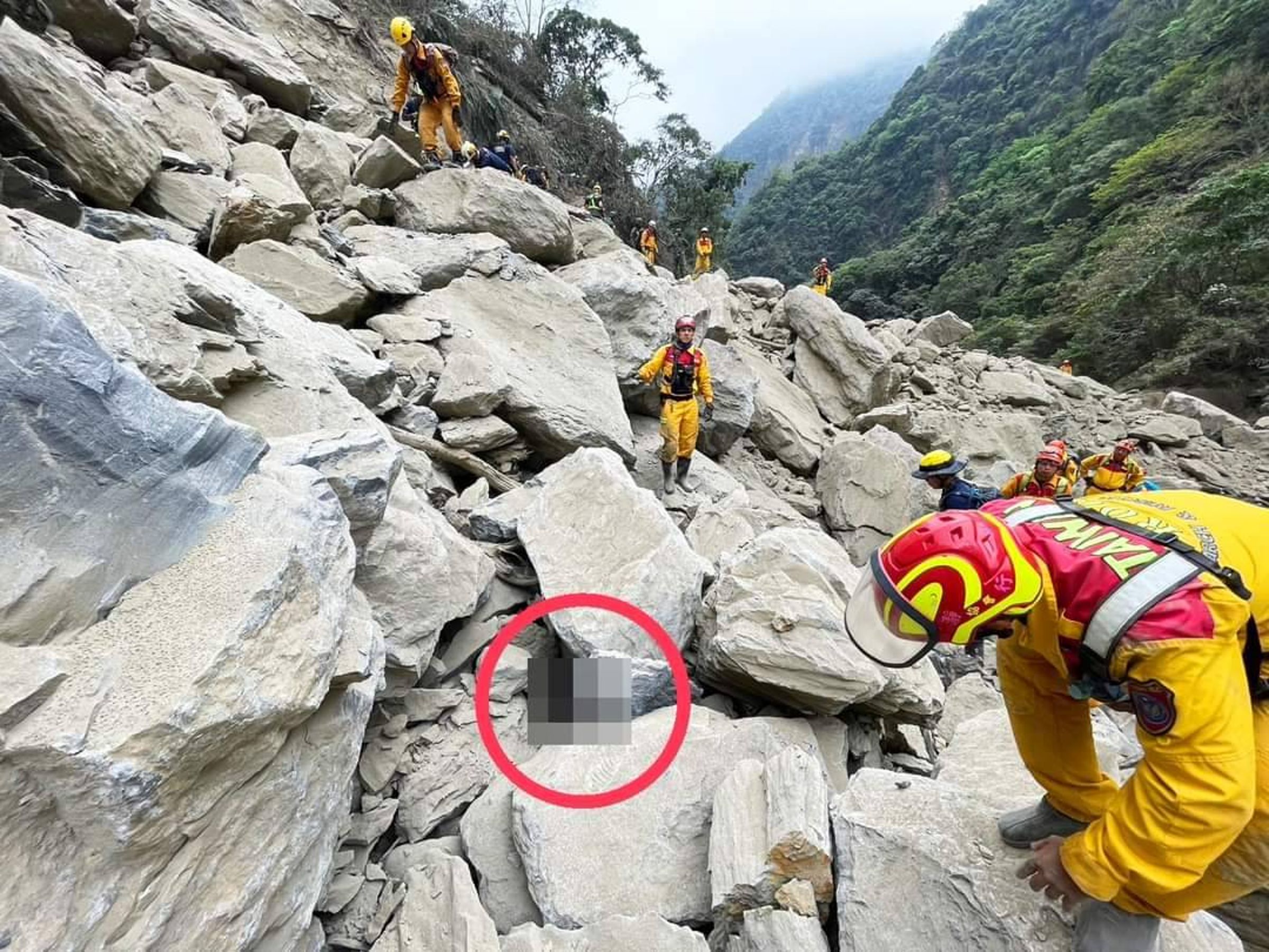 特搜隊人員挺進砂卡礑步道,發現2具被壓在巨石下的遺體。(台東、屏東搜救隊提供)