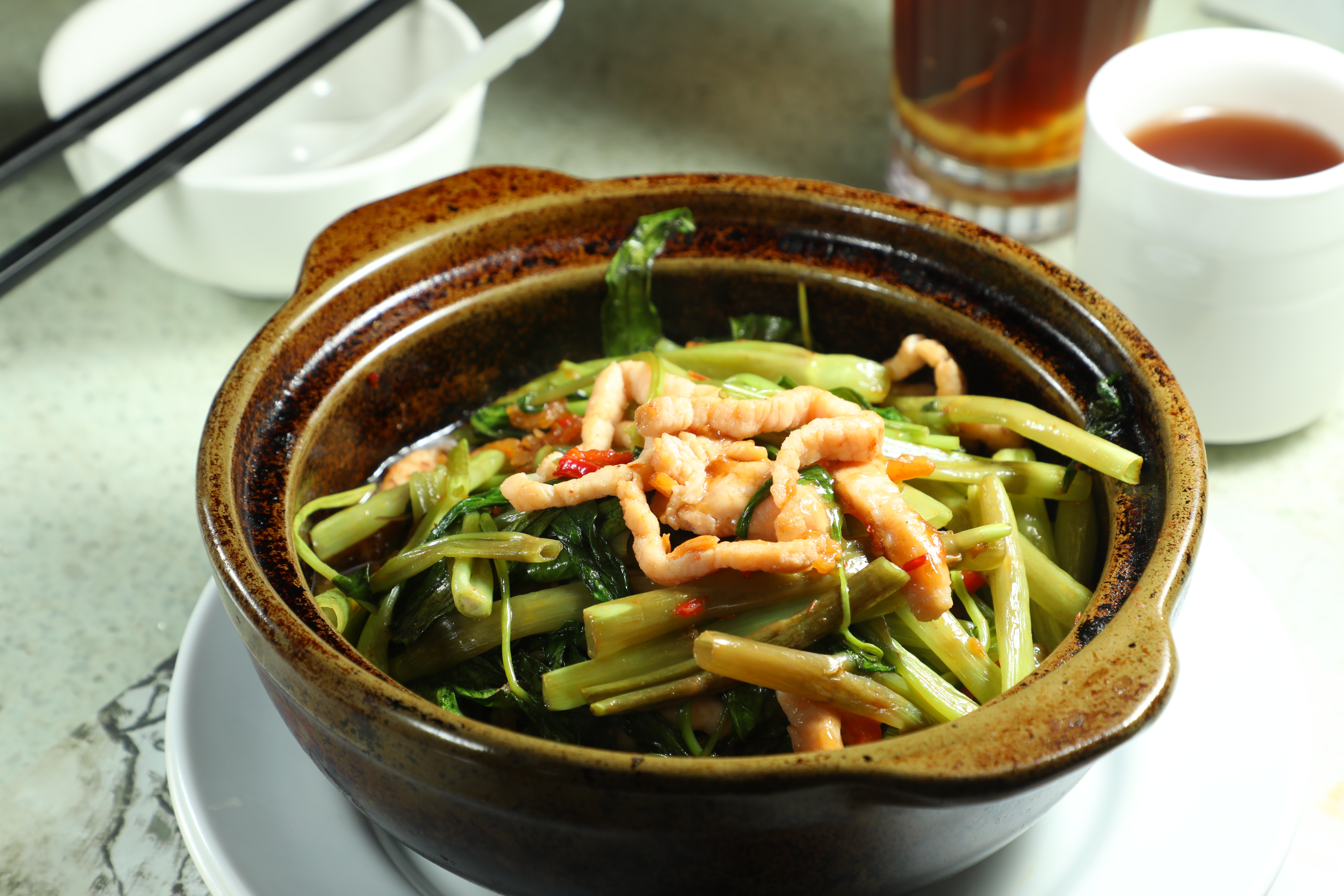 「啫啫時菜肉絲煲」上菜時整鍋熱氣蒸騰，空心菜帶有微微焦香。（港幣98元／份，約NT$374）
