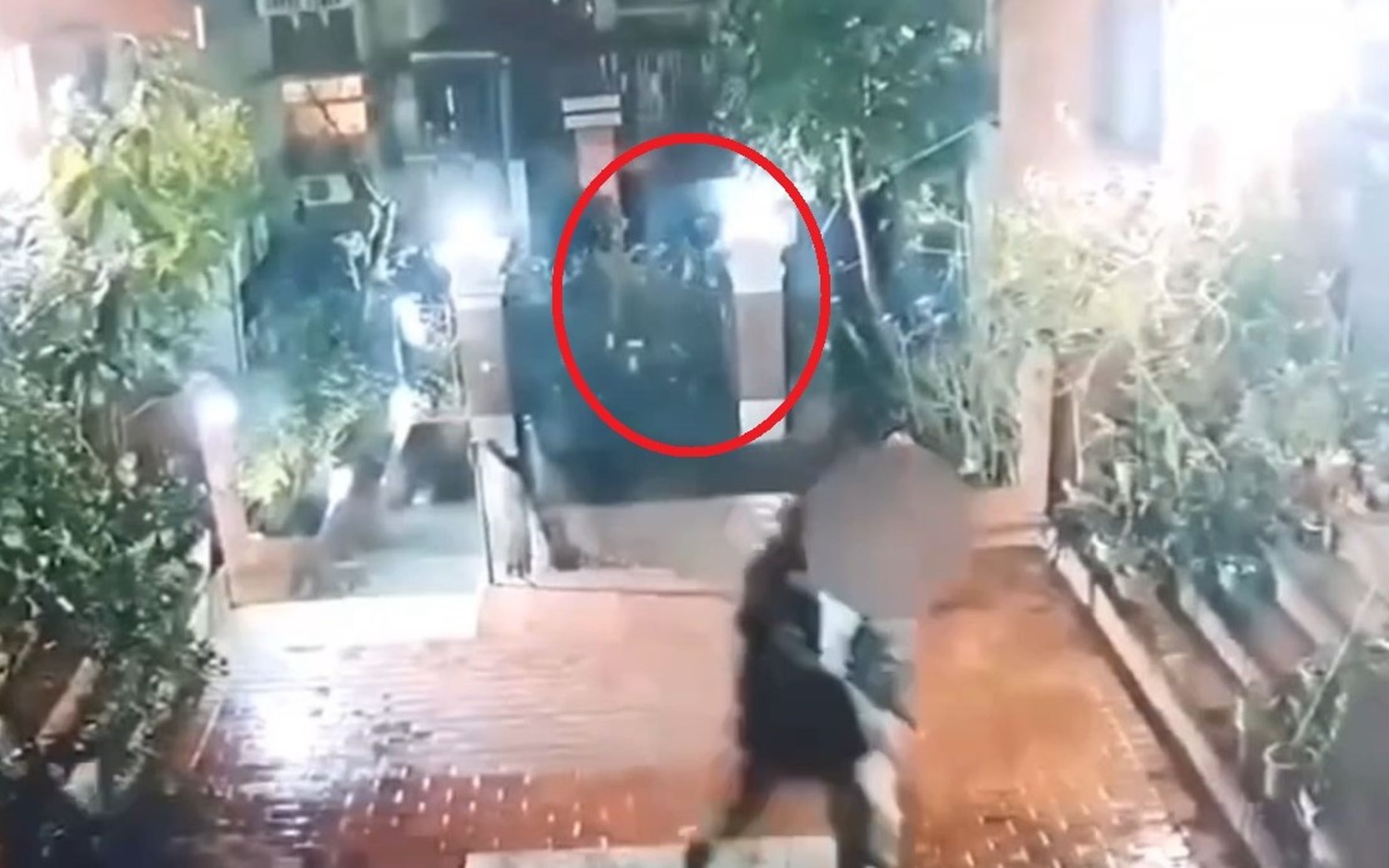 鄒男(右)步行返回住家社區時,黃男(紅圈)也翻牆進入社區,伺機持刀刺臀。(翻攝畫面)