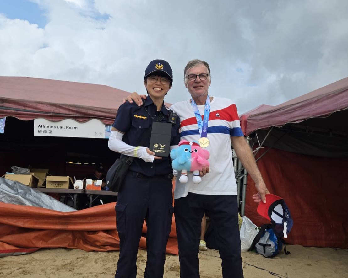 來自法國的71歲選手與找回金牌的警員合影。（警方提供）