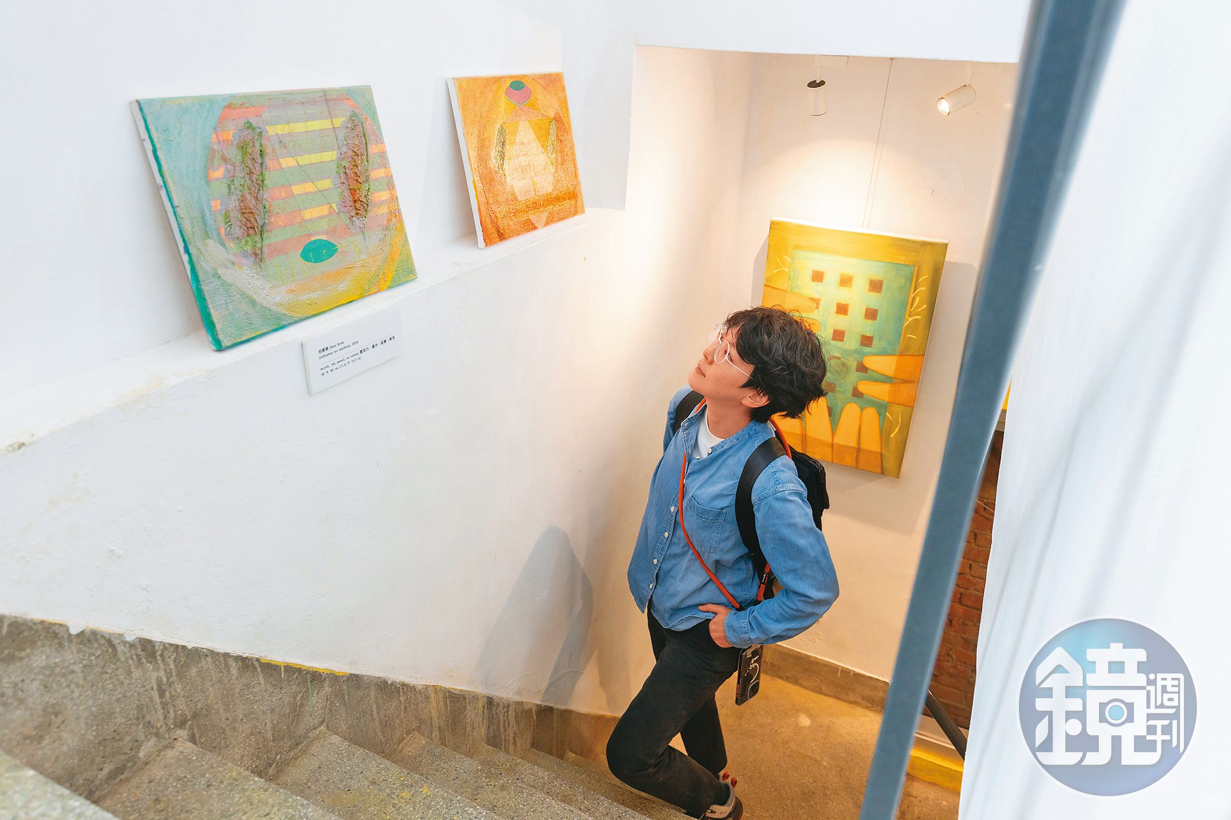 樓梯間邊牆上展示著陽明交大教授包德樂的畫作,宣揚他追求和平的理念。