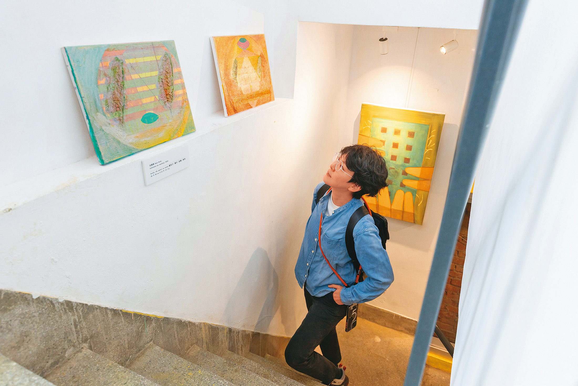 樓梯間邊牆上展示著陽明交大教授包德樂的畫作,宣揚他追求和平的理念。