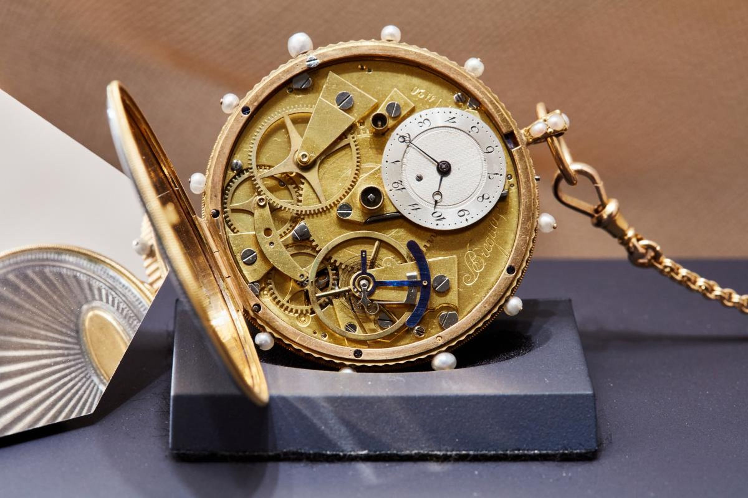 寶璣大師於1810年10月22號，售予Titan先生的編號2627-Tact watch觸摸式懷錶，採用機刻雕花飾紋灰色錶殼，40毫米尺寸屬小型款式，訂製機芯採用中央發條盒、三臂黃銅擺輪、紅寶石工字輪擒縱結構，以及降落傘式避震裝置。錶殼外的金質鑲嵌珍珠指針與機芯時針同步運轉，使用者能以觸摸感受指針位置得知時間。
