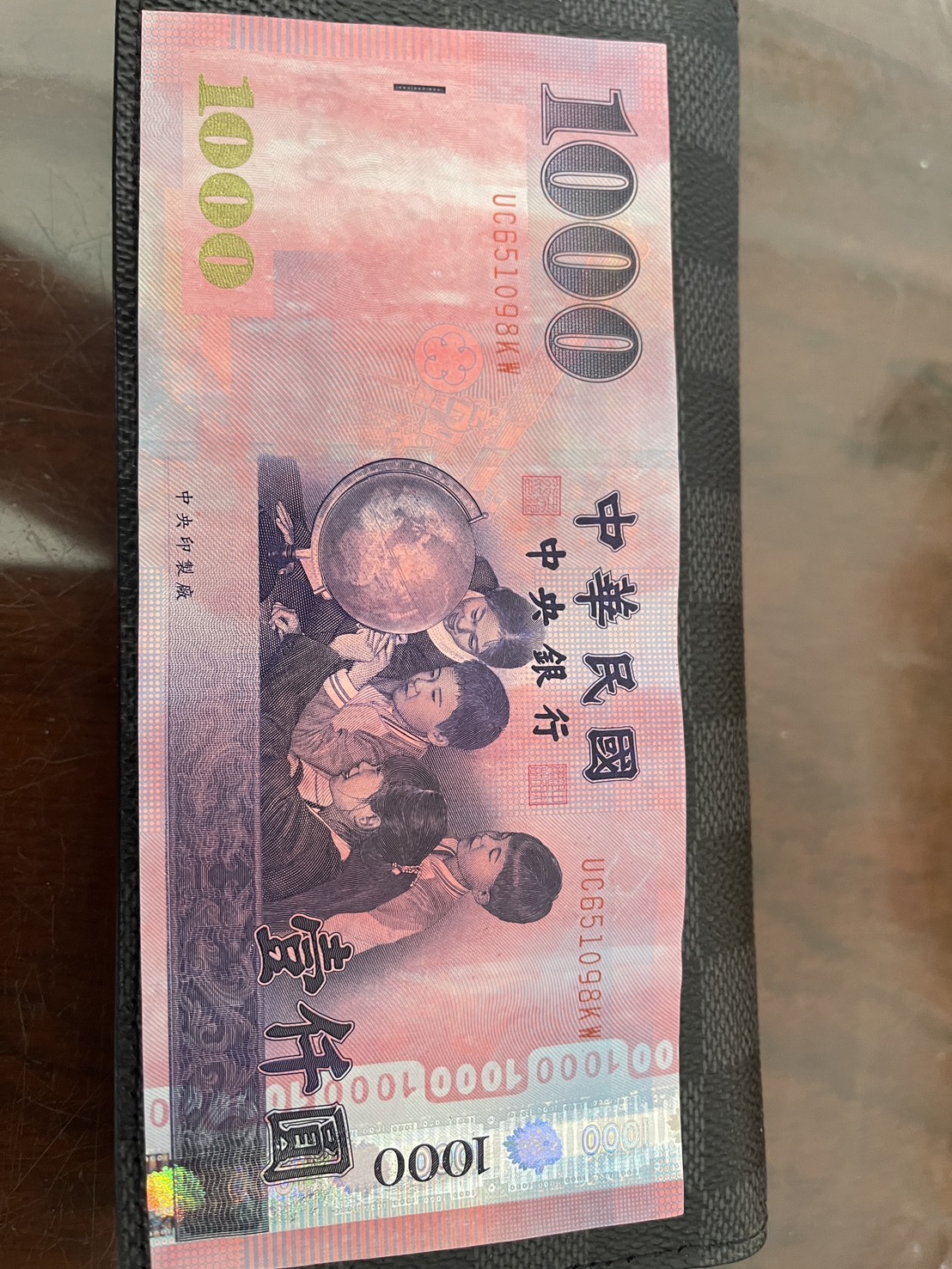 本刊讀者在追粉紅超跑的回程，領到一張粉紅色變異仟元鈔，讓他直呼太幸運。（讀者提供）