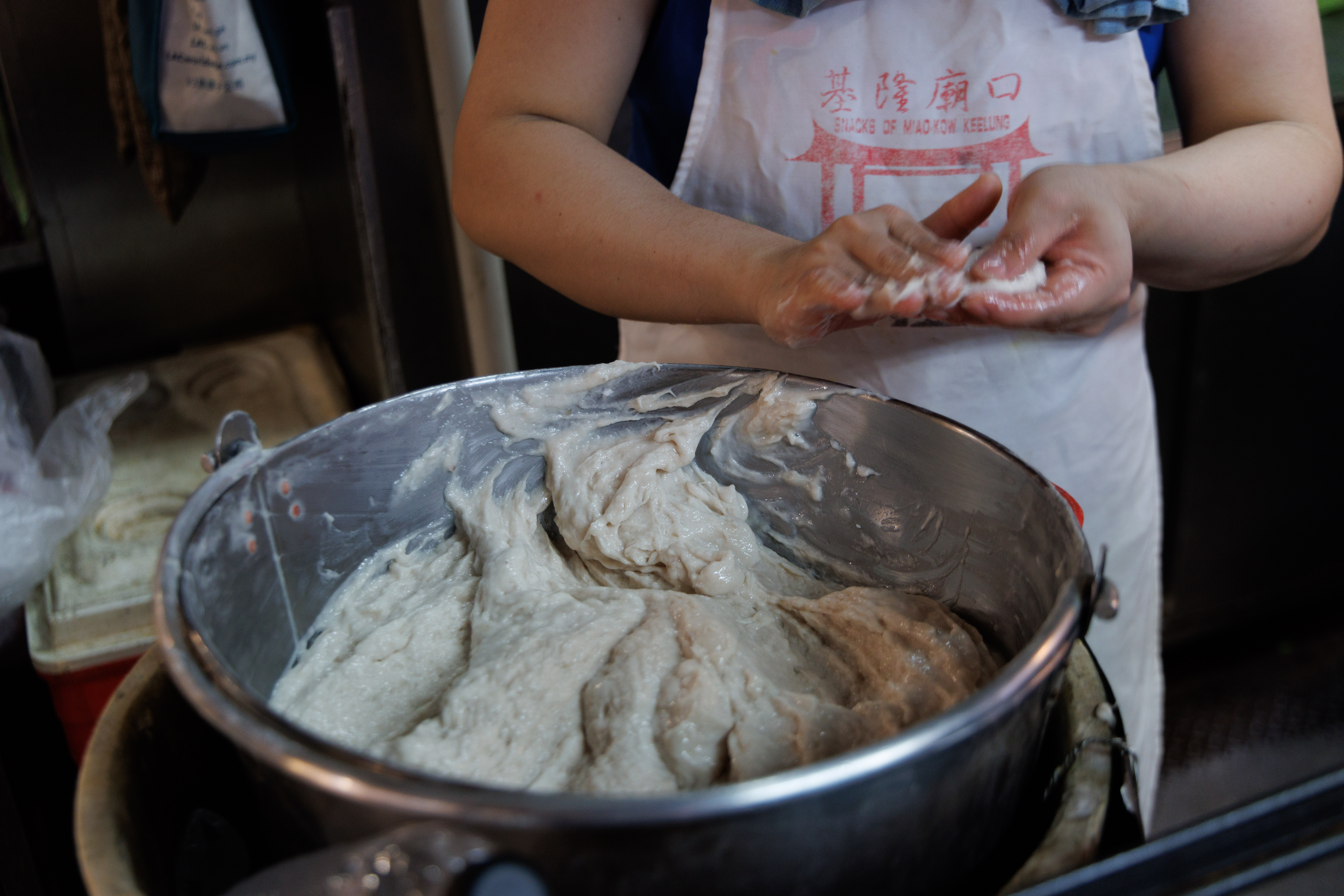 天婦羅的製作需要分工合作，一人負責抓魚漿拋進油鍋。