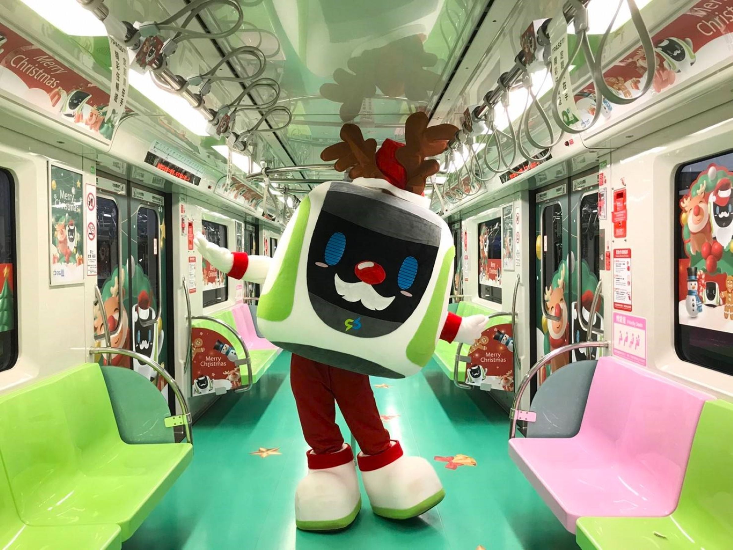 台中捷運耶誕列車發車了，中捷吉祥物小綠綠邀民眾一起來搭車。（中捷提供）