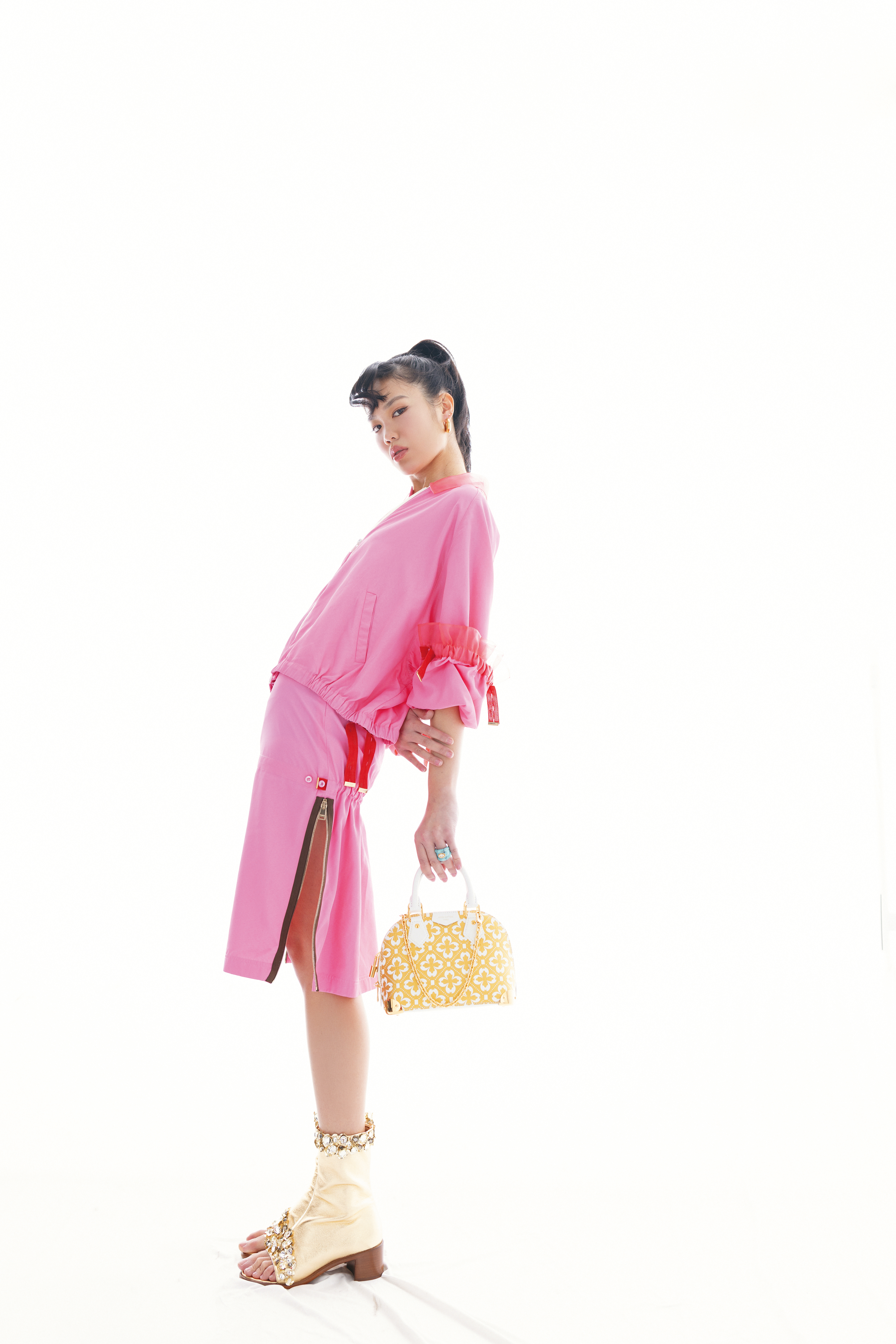 粉紅色飛行員外套 NT$102,500 by FENDI、粉紅色半身裙 NT$49,200 by FENDI、金色綴寶石與亮片露指靴 NT$142,000 by LOUIS VUITTON、GUCCI Blondie系列耳環 NT$30,700 by GUCCI、Dior Rocks戒指 NT$15,000 by Dior、Alma Trunk BB NT$141,000 by LOUIS VUITTON。