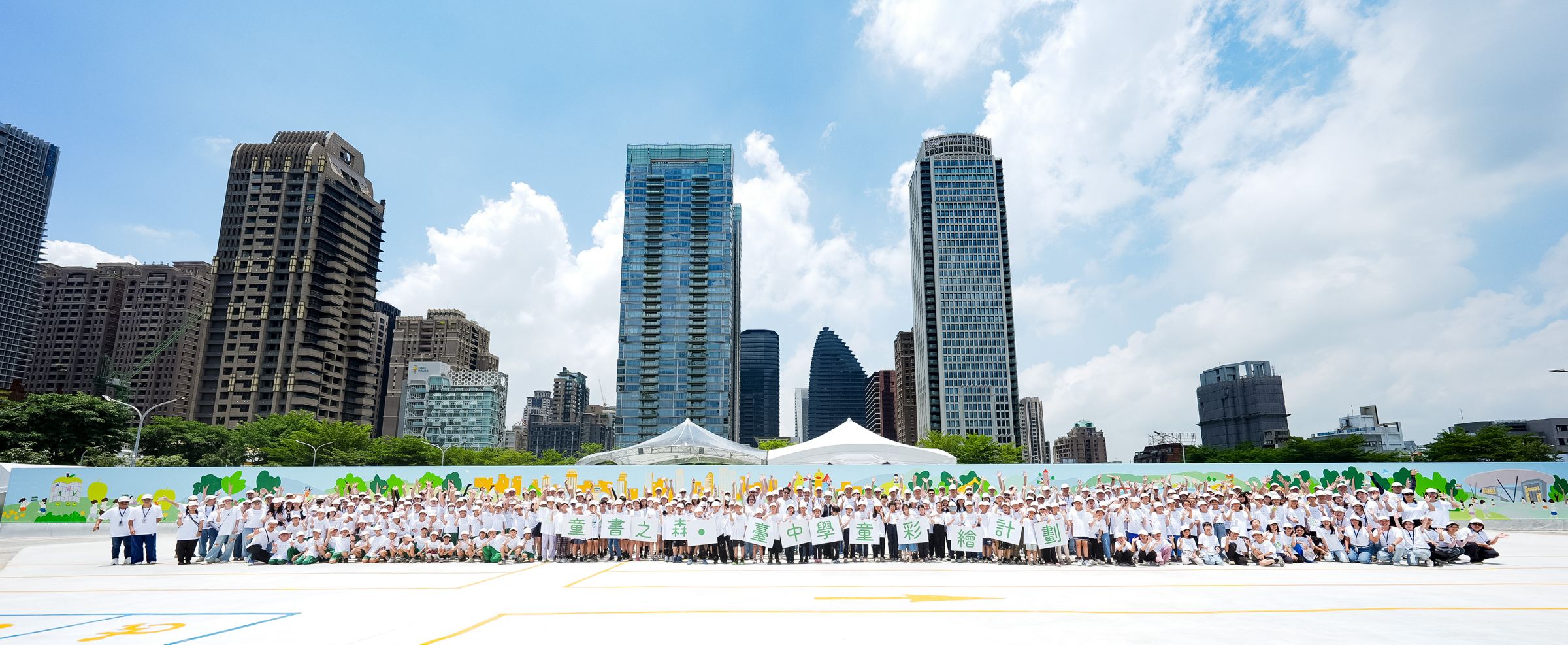 台中市政府與聯聚文教基金會，特別策劃充滿溫度與創意的彩繪圍籬活動，邀請大同國小、惠文國小與惠來國小超過200位學童，以畫筆描繪心中的「童書之森」。（聯聚建設提供）