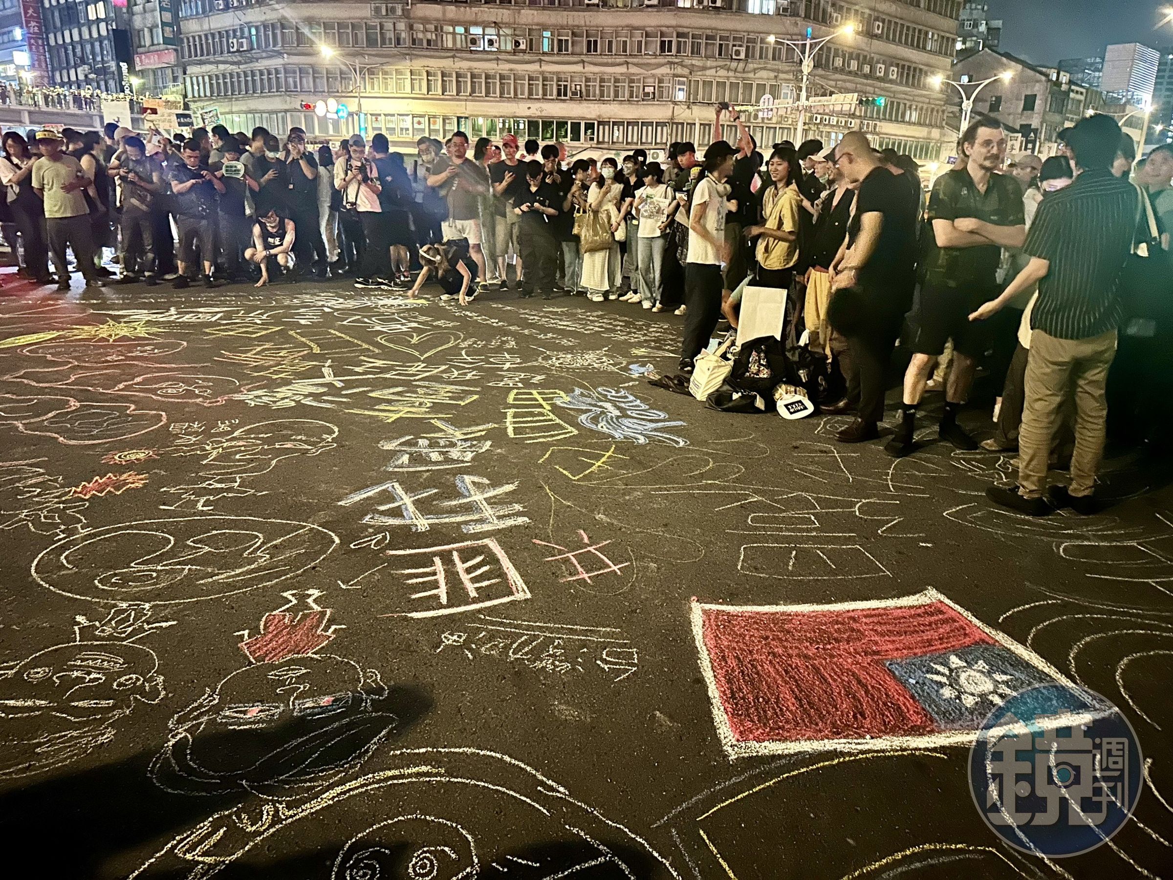 民眾不只舉標語表達訴求,還在柏油路上作畫。