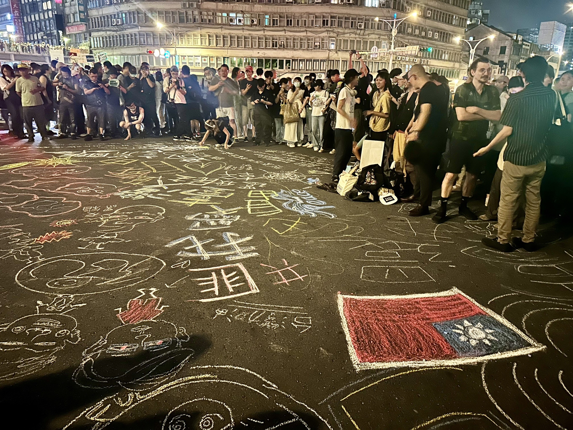 民眾不只舉標語表達訴求，還在柏油路上作畫。