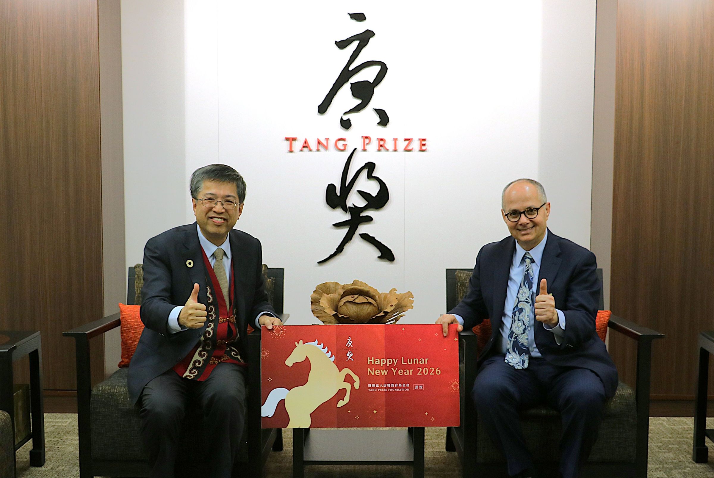 奧馬爾.亞基教授(右)來台適逢農曆新年,唐獎教育基金會執行長陳振川(左)也送上了應景禮物,讓他也體驗一下農曆新年。(唐獎提供)