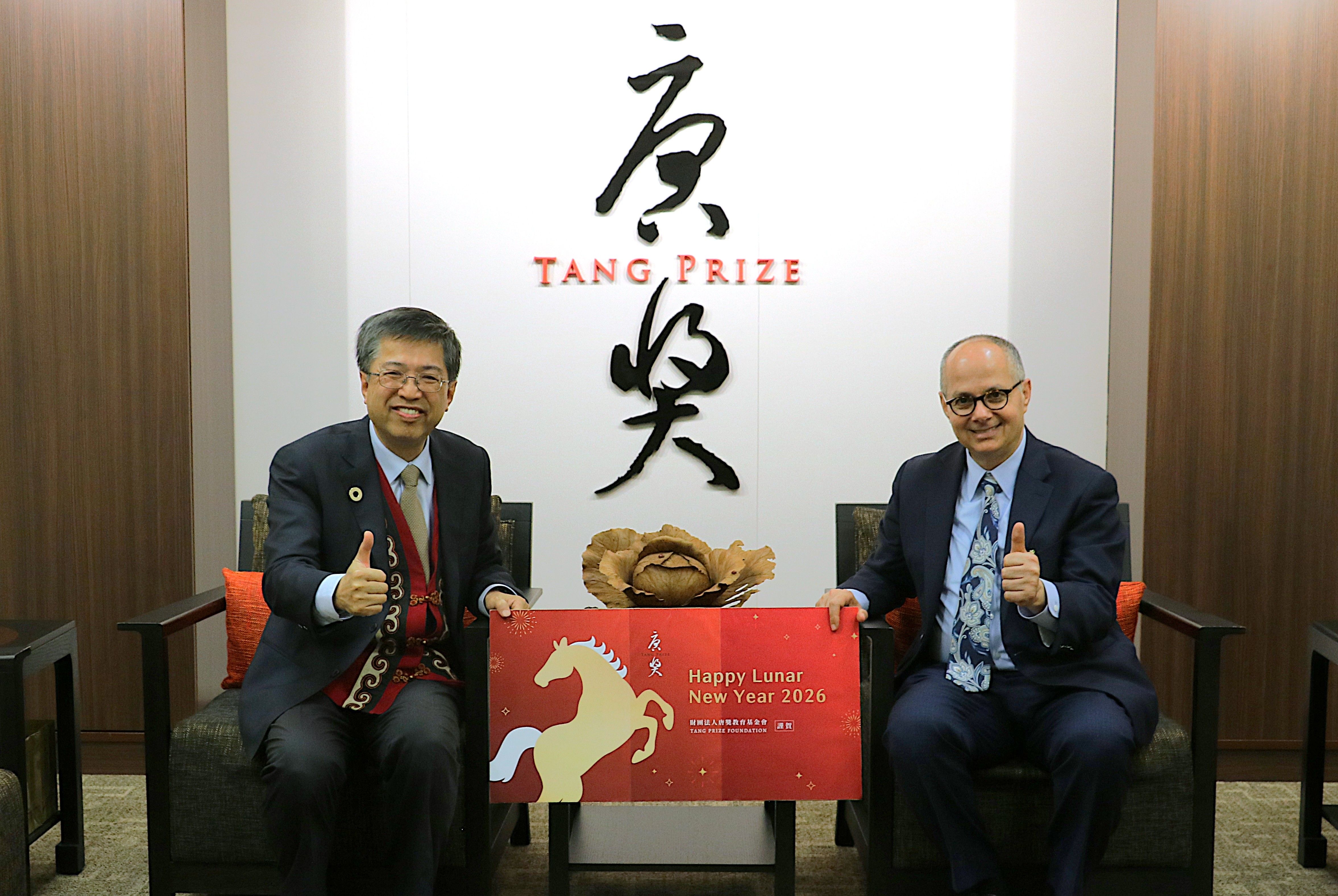 奧馬爾.亞基教授(右)來台適逢農曆新年,唐獎教育基金會執行長陳振川(左)也送上了應景禮物,讓他也體驗一下農曆新年。(唐獎提供)