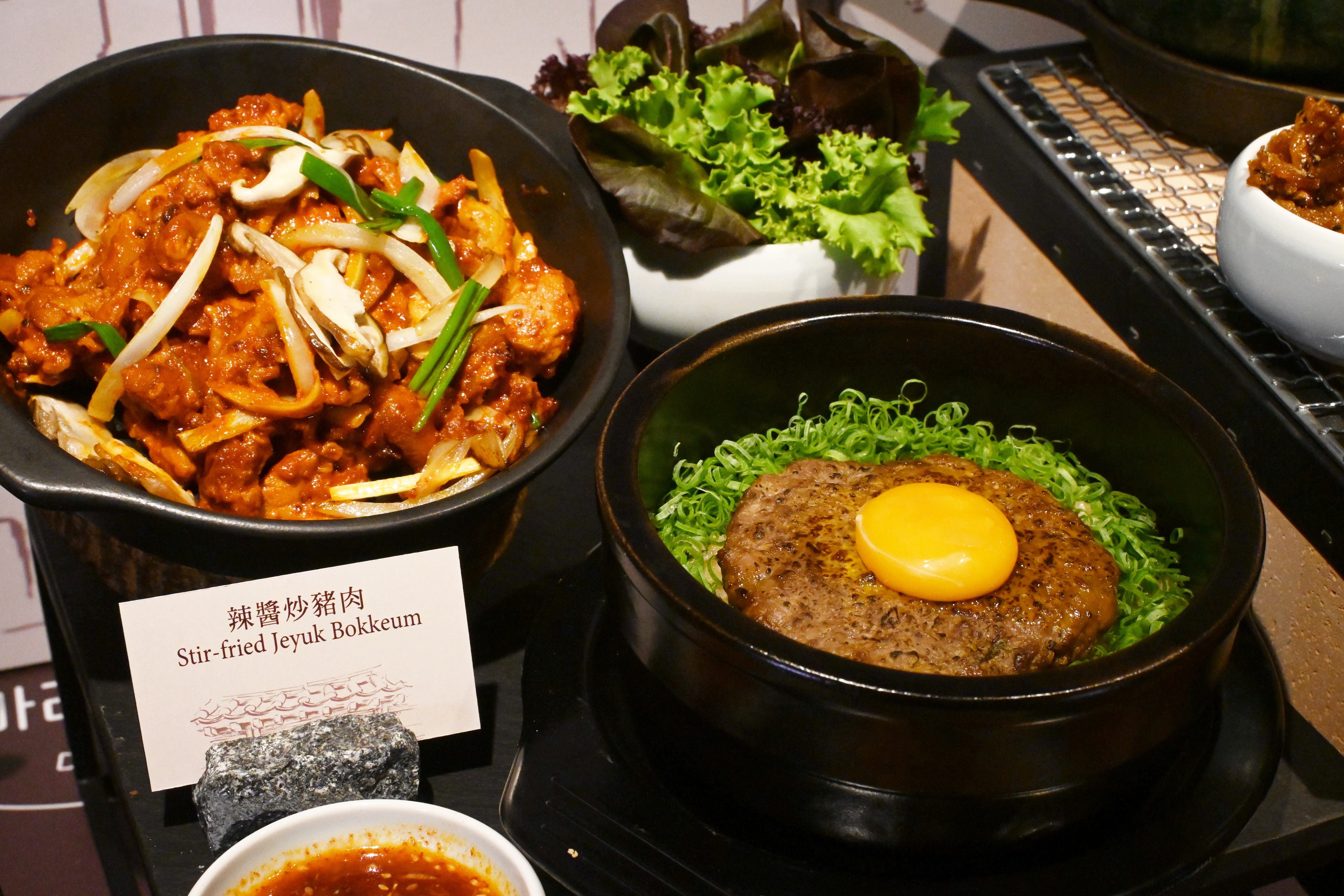 一樓azie推出4款韓式定食,每份皆搭配多道精緻韓式小菜,圖為「辣醬炒豬肉 」(左,980元/份)與「傳統韓式烤美國牛肉餅」(右,1,080元/份)。