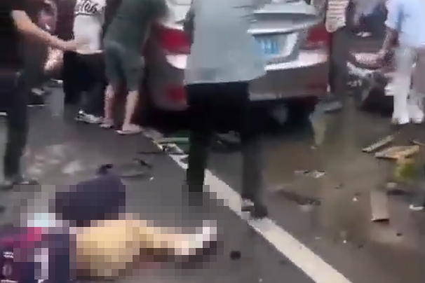 一輛銀色轎車突然衝撞校門口人群，當場撞倒多名正在接送或等候的家長與小學生。（翻攝畫面）