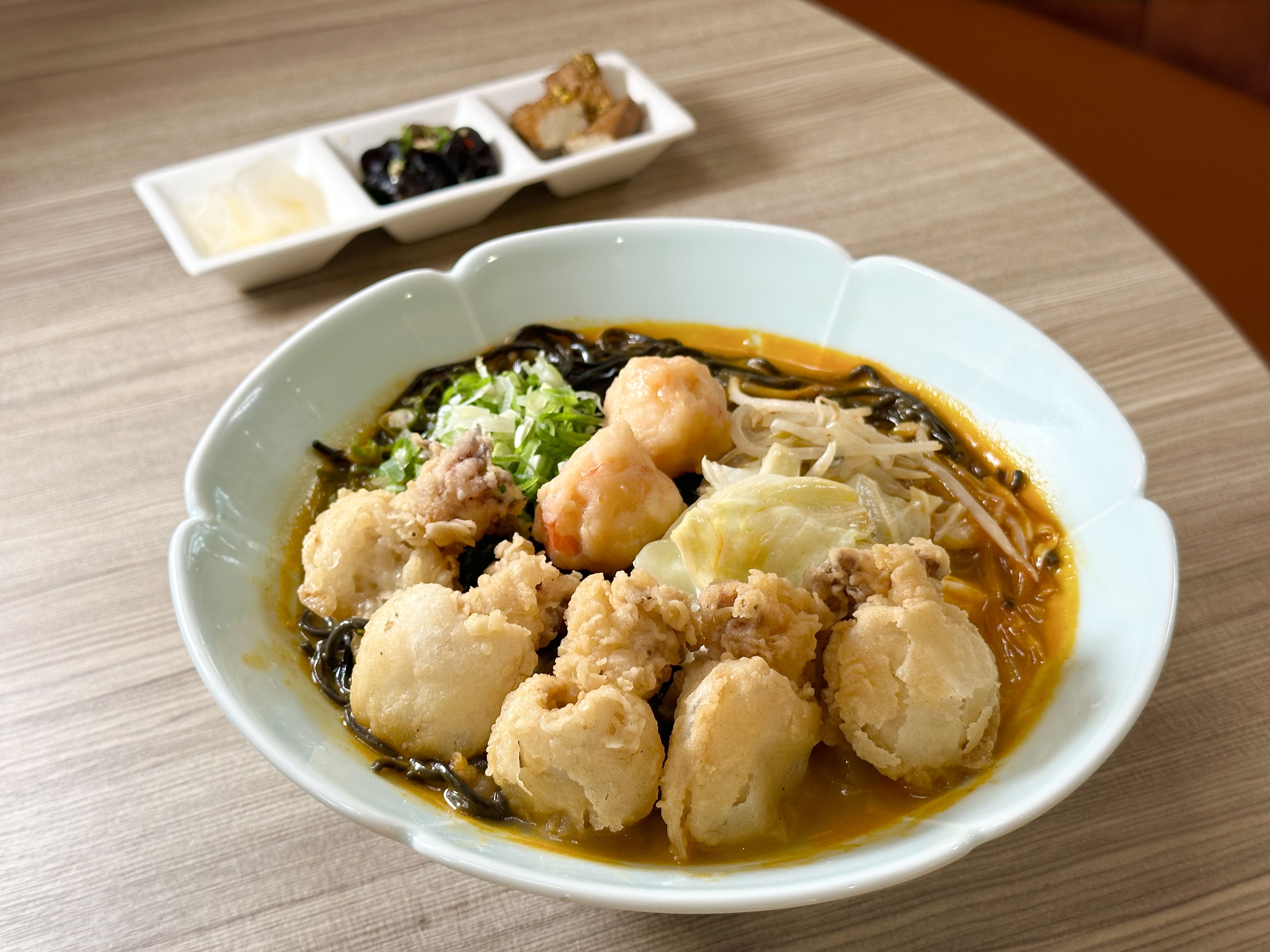 「花黑pun豪華海鮮拉麵」配料有酥脆彈口的炸小花枝，軟嫩的蝦滑，墨魚細麵滑Q不爛，湯頭蝦味濃厚。（368元／碗）