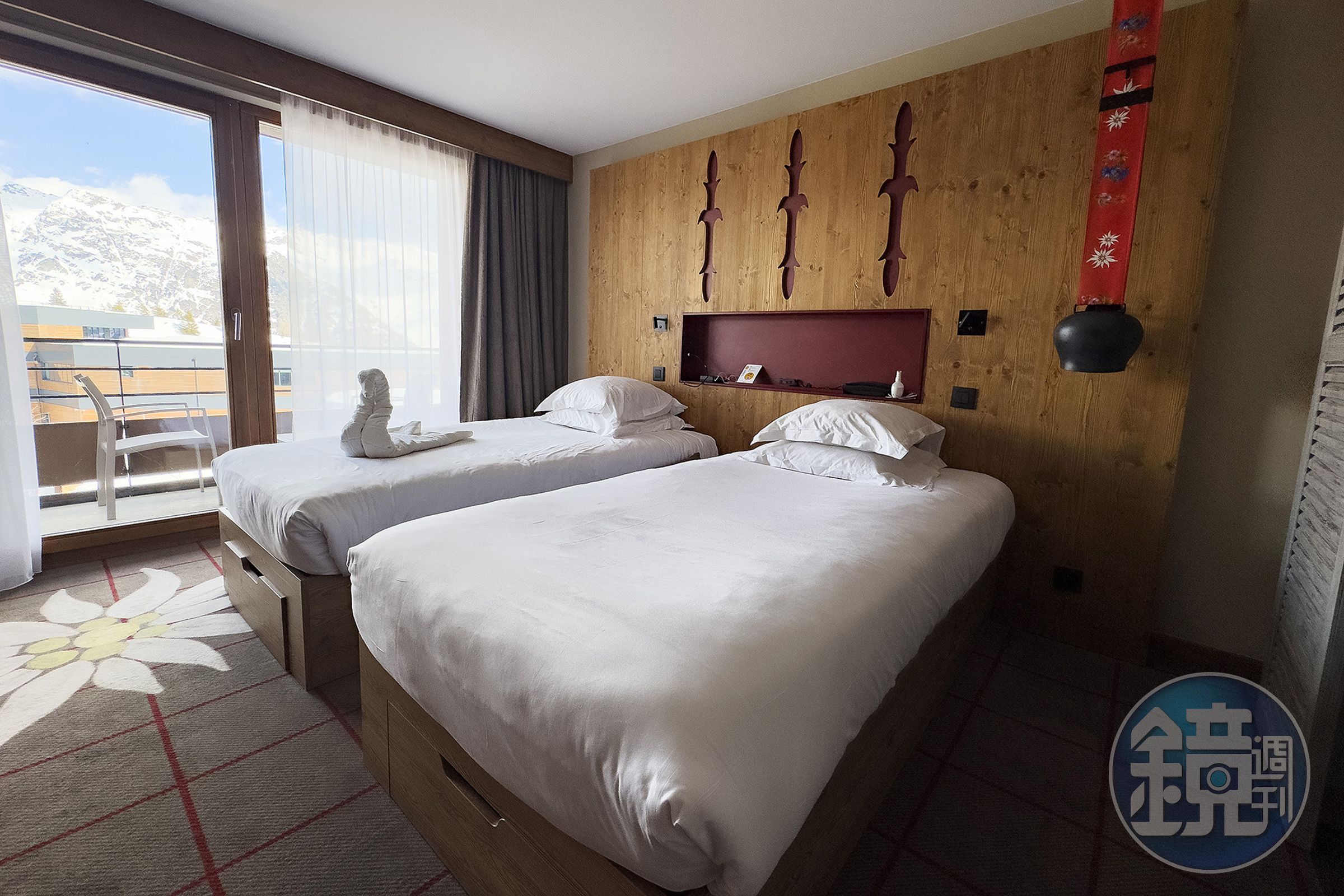 Club Med La Rosière的客房融合阿爾卑斯風格的溫馨客房內部陳設，床頭燈有牛鈴造型特色。