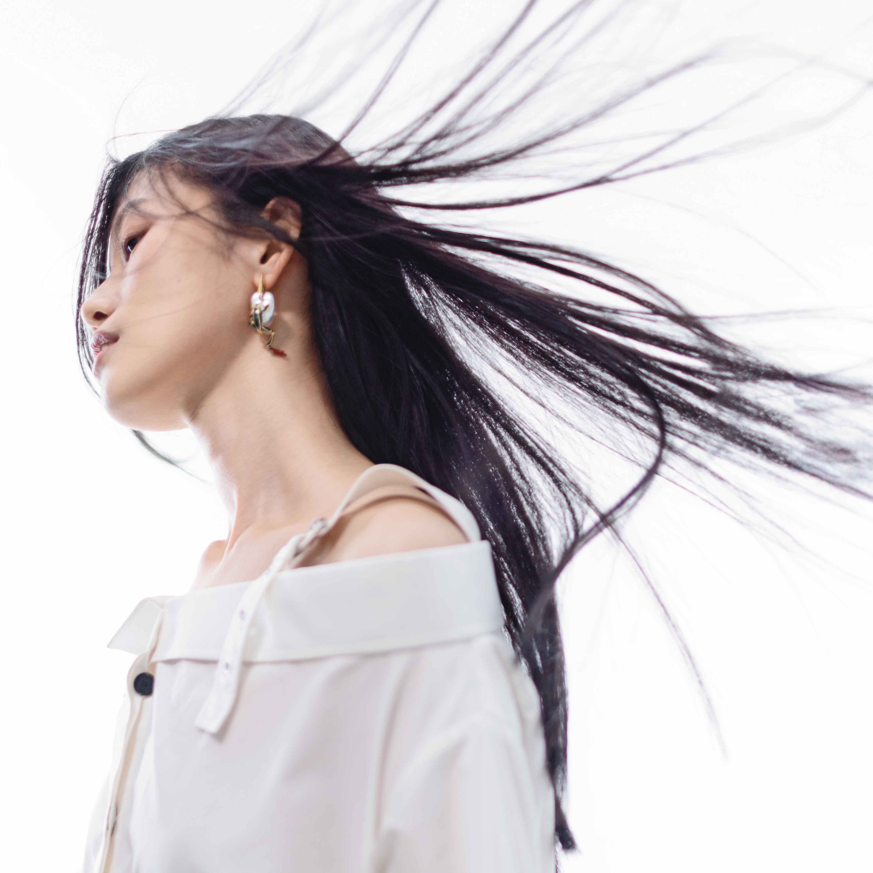 白色露肩襯衫洋裝 NT$130,000 by Dior／Rana珍珠青蛙耳環 NT$67,700 by BOTTEGA VENETA／金色竹節手環 價格店洽 by GUCCI