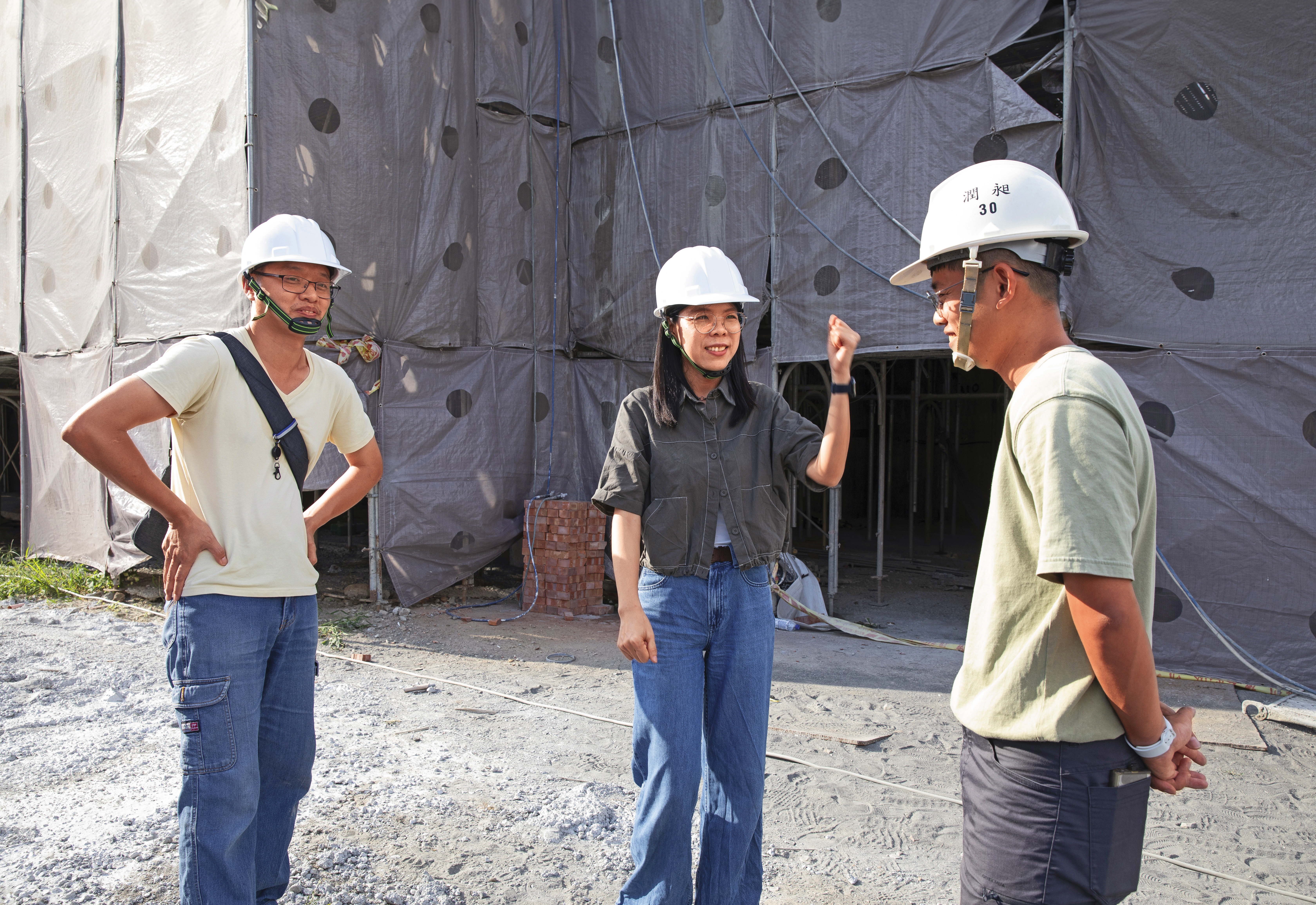 劉育育（中）與苑裡市場重建案工地主任聊天，關心歷史建築修復進度。