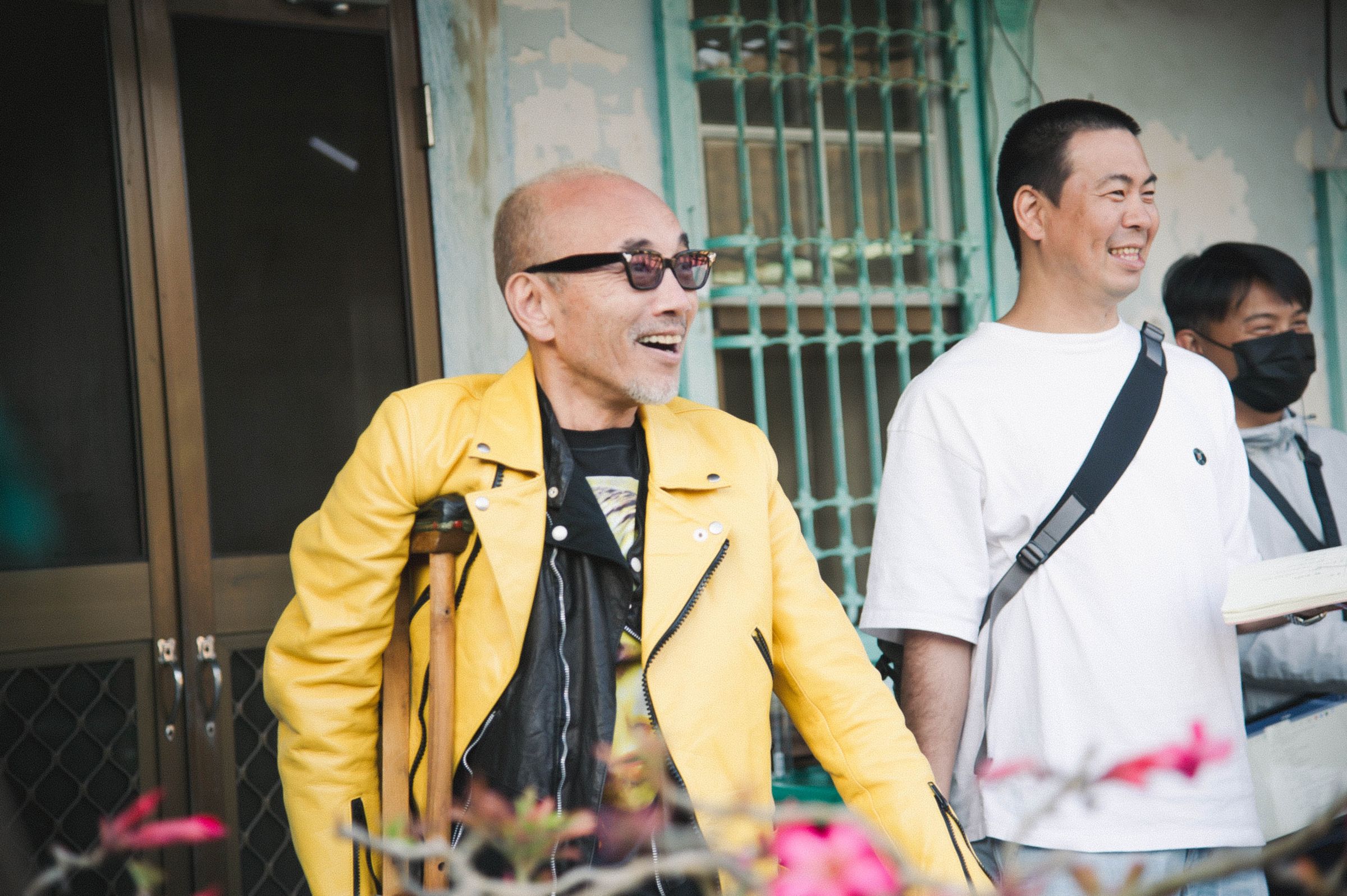 日星竹中直人每次接演新作品就會買一件新衣服，得知《雨中的慾情》在台灣取景拍攝，特地買了身上這件黃色皮外套，右為導演片山慎三。（光年映畫提供）