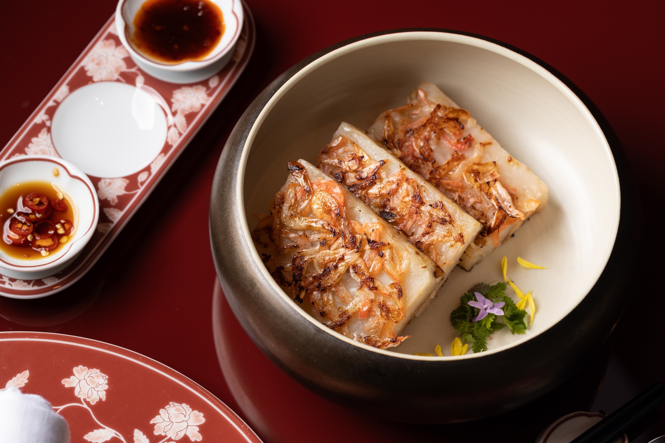 「香煎櫻花蝦蘿蔔糕」外層煎至金黃酥香，入口能同時感受櫻花蝦鮮香、蘿蔔清甜與米香。（480元／份）