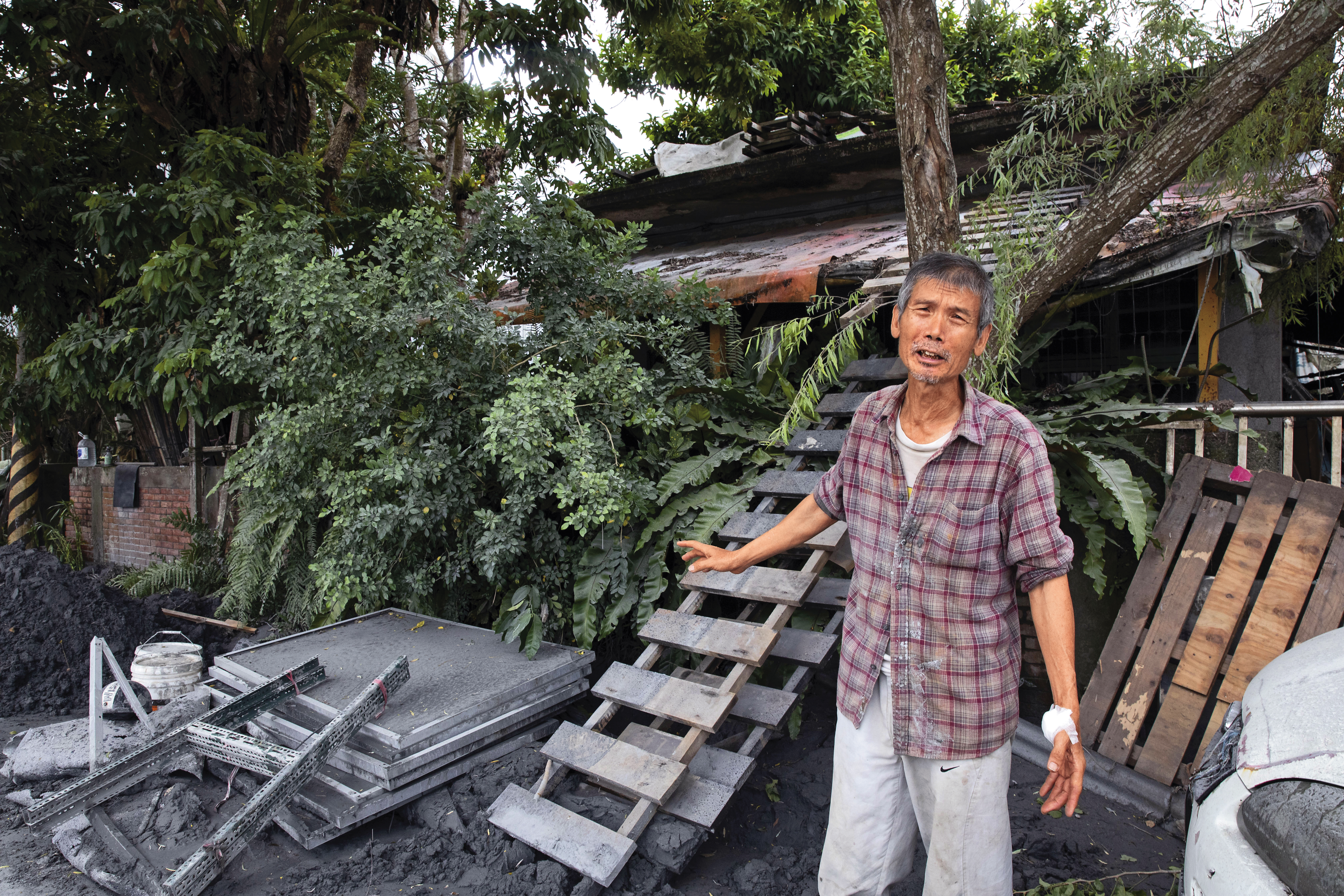 王先生背後的棧板，讓很多人能爬到屋頂，得以生還。