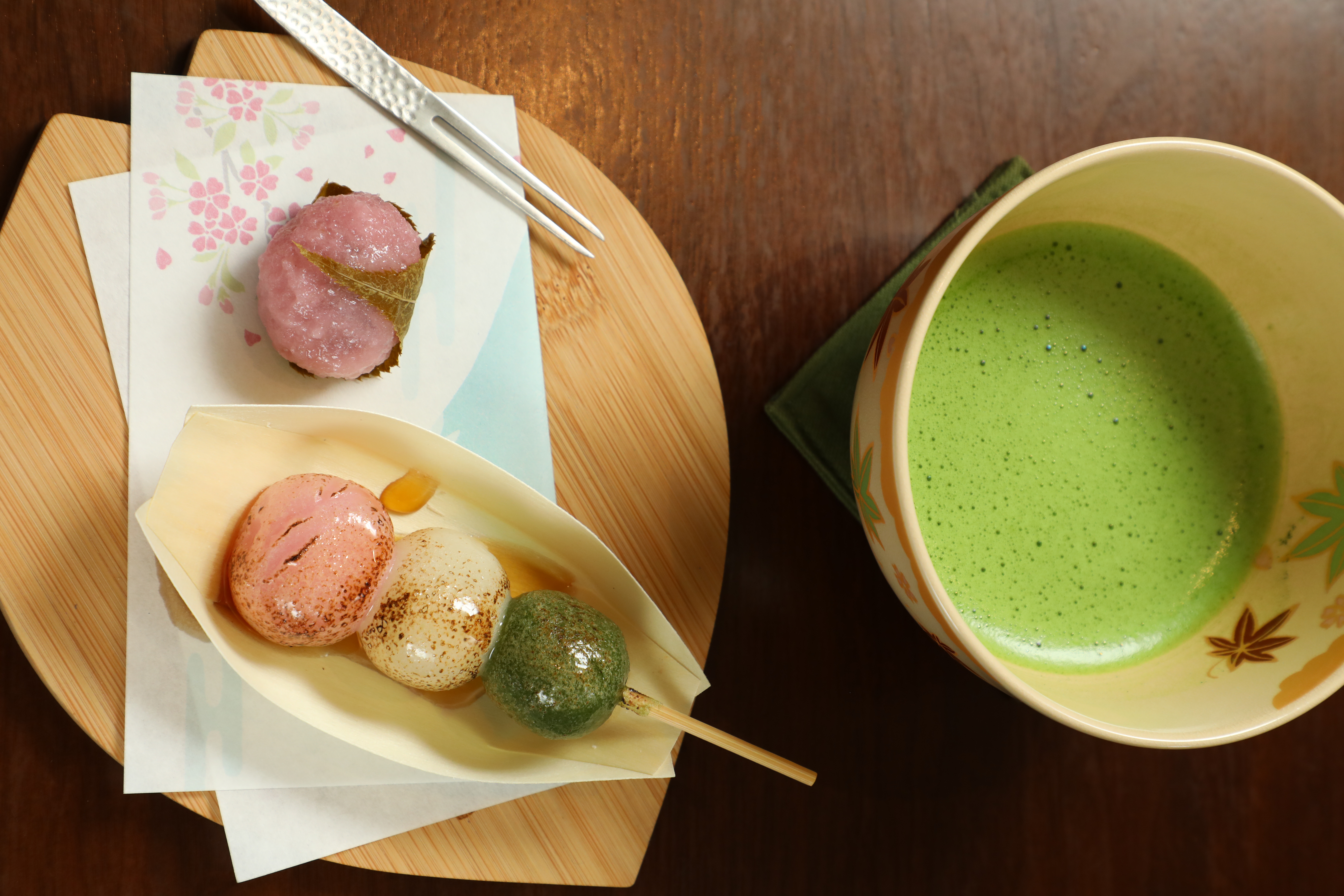 手刷抹茶使用小山園抹茶中的上等抹茶「雲鶴」（後，250元／杯）口感輕盈；加上「櫻餅」（左前，60元／顆）與「花見糰子」（右前，80元／份）就是春日賞花最佳搭配。