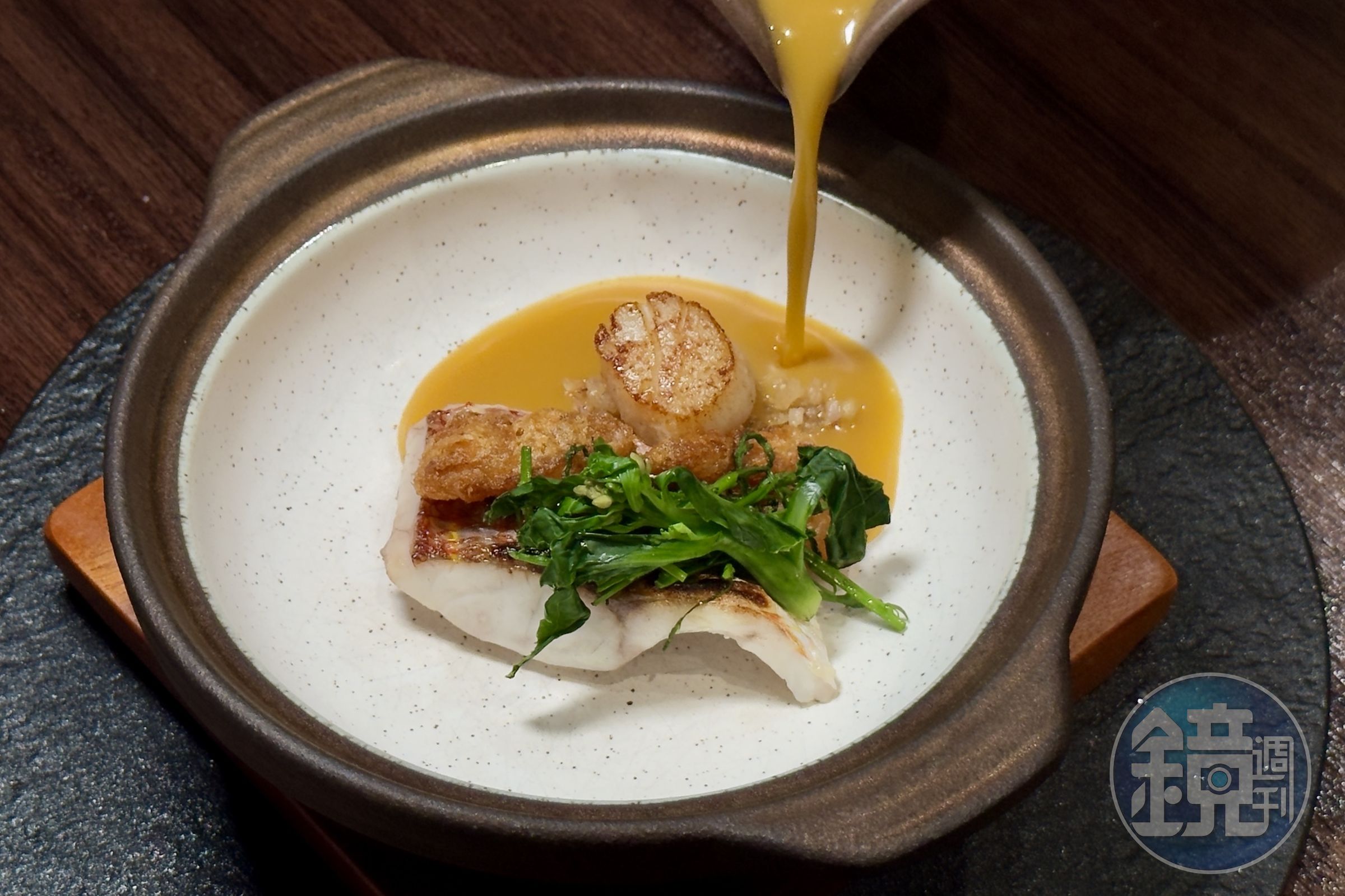 「時令魚／西班牙海鮮湯飯」把魚、蝦、貝高湯與米打成濃潤米湯，搭配金線魚、干貝與酥炸花膠，呈現跨文化的湯飯滋味。