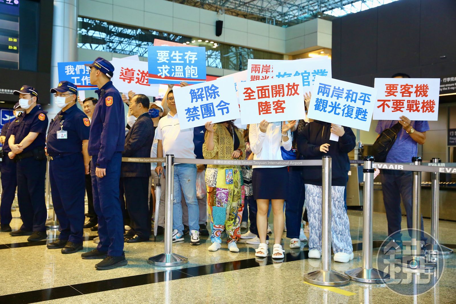 傅崐萁率立委們前往中國，許多支持者舉牌倡議。（圖／鏡週刊）