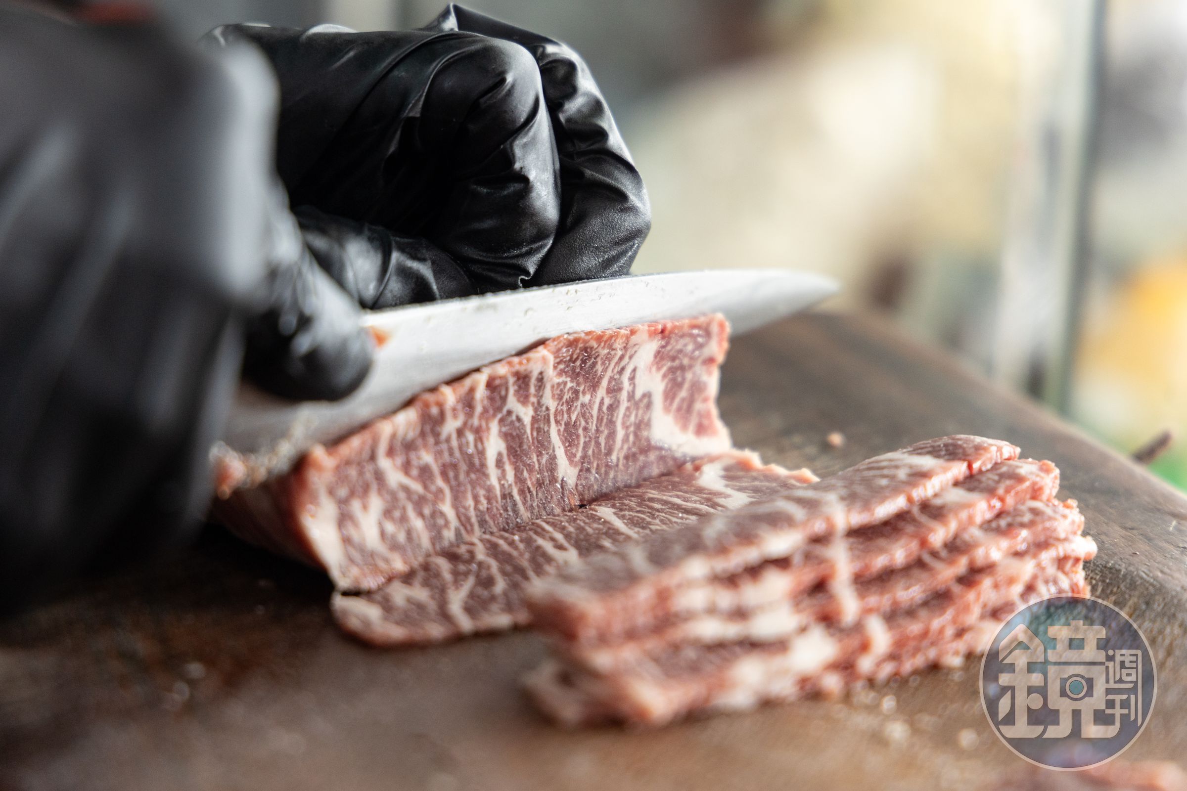 客人川流不息,廚師手不停地處理牛肉。
