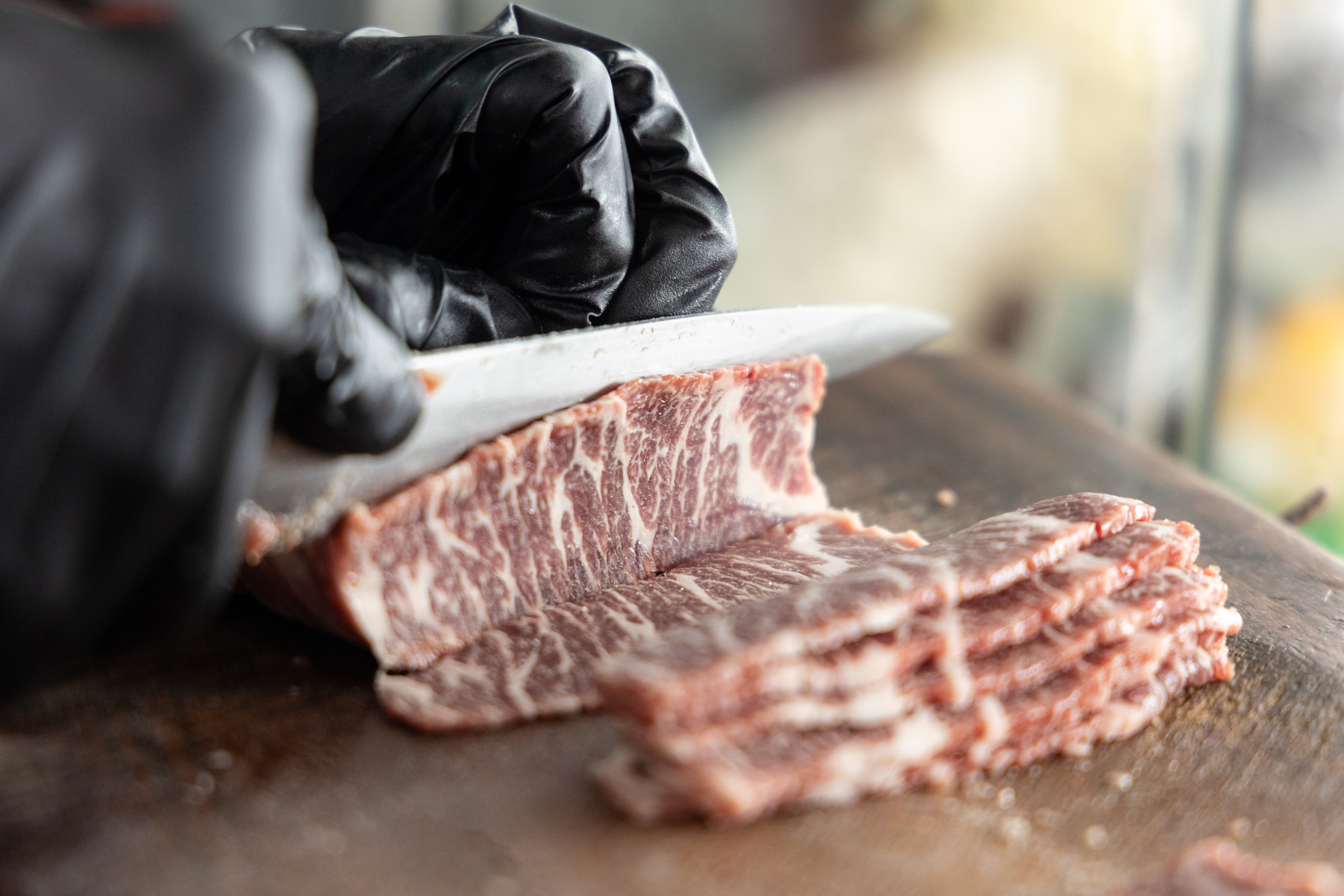 客人川流不息,廚師手不停地處理牛肉。