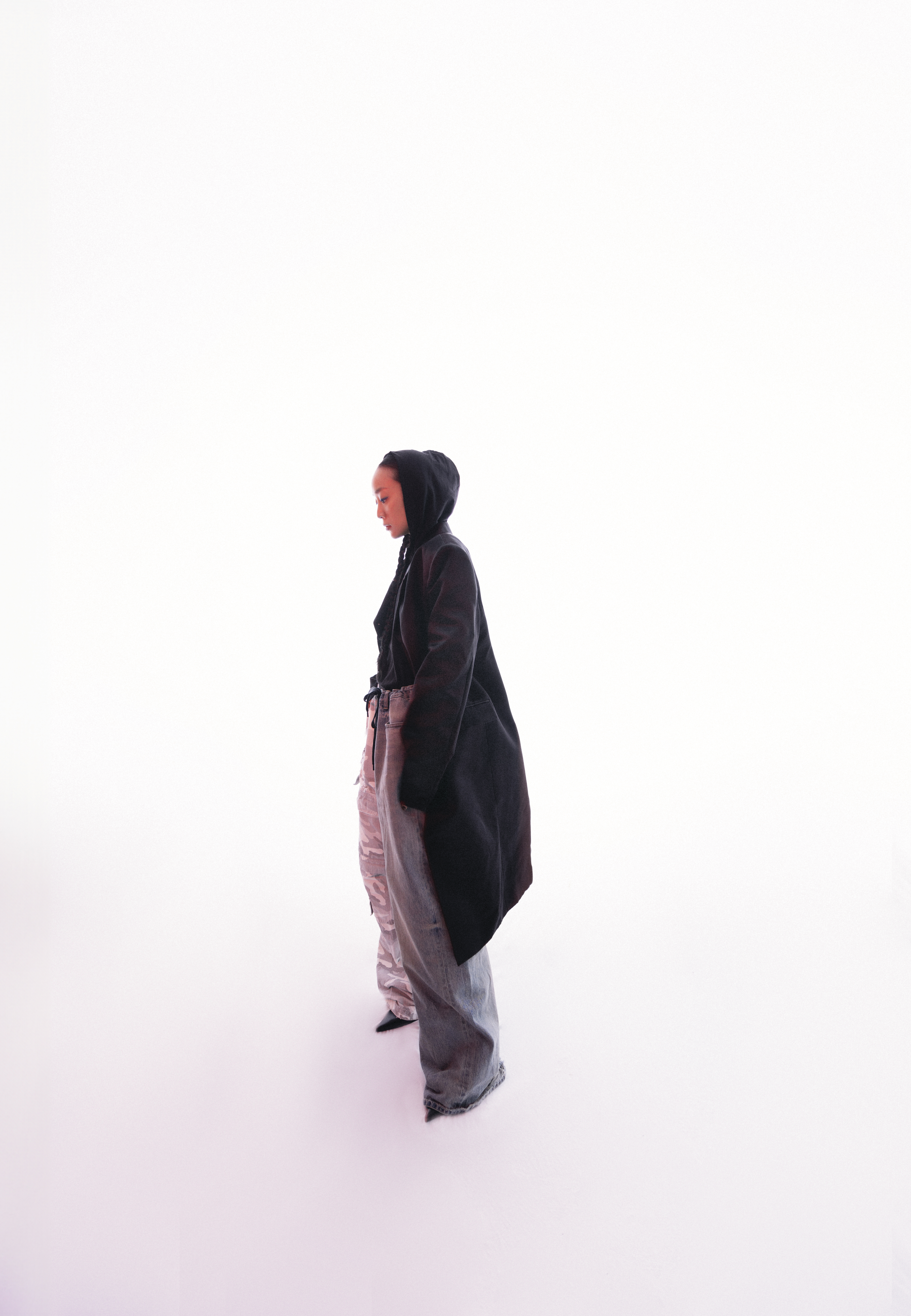 公爵夫人黑色絲緞繭形大衣 NT$215,000 by Givenchy；黑色連帽棉質T NT$25,000 by Balenciaga；拼接丹寧褲 NT$86,400 by Balenciaga；黑色尖頭鞋 NT$36,500 by Givenchy。
