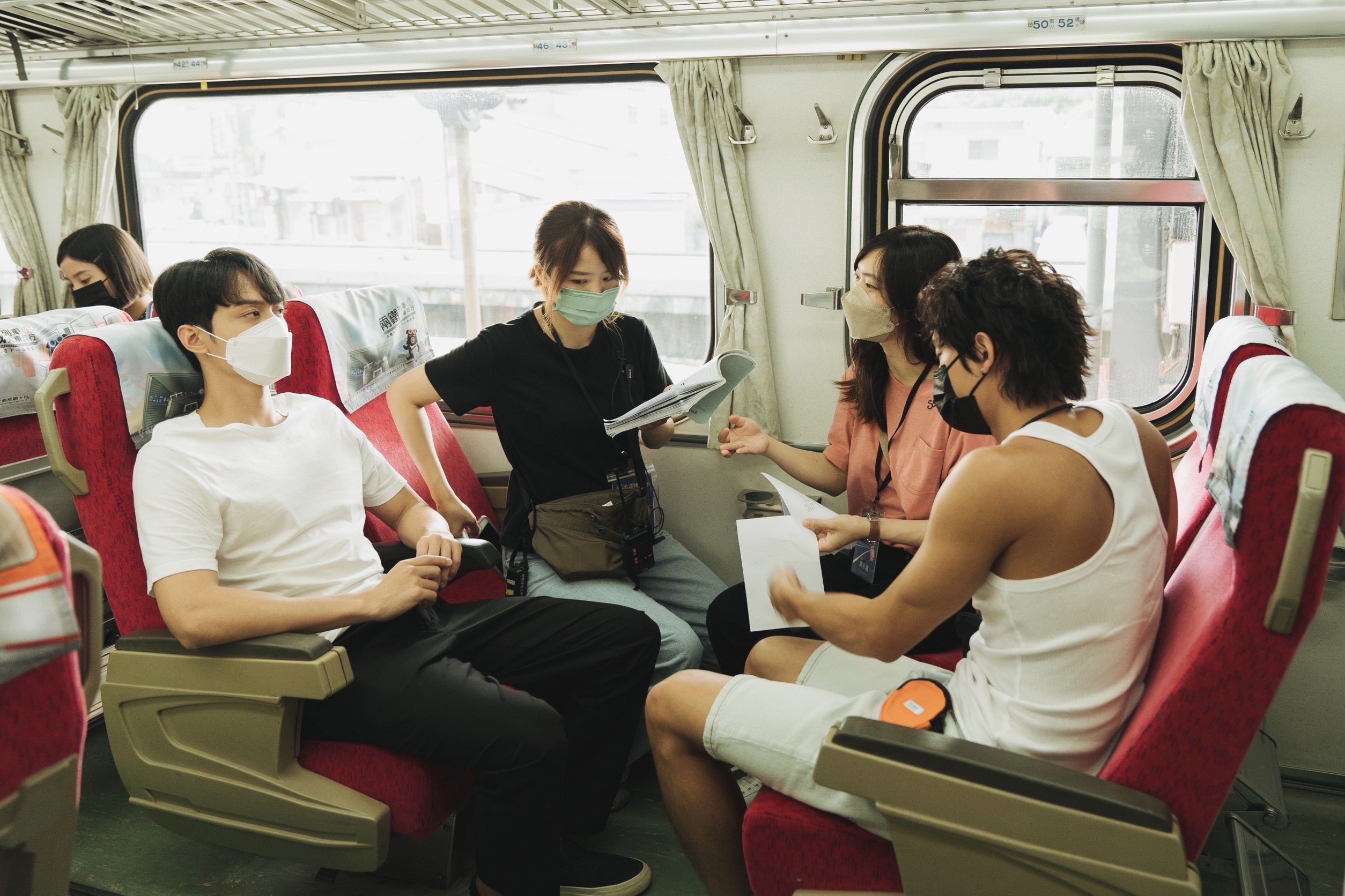 導演鄧依涵(右2)在火車上和范少勳(右)、攝影鍾艾與劉俊謙講戲。(抓馬文化提供)